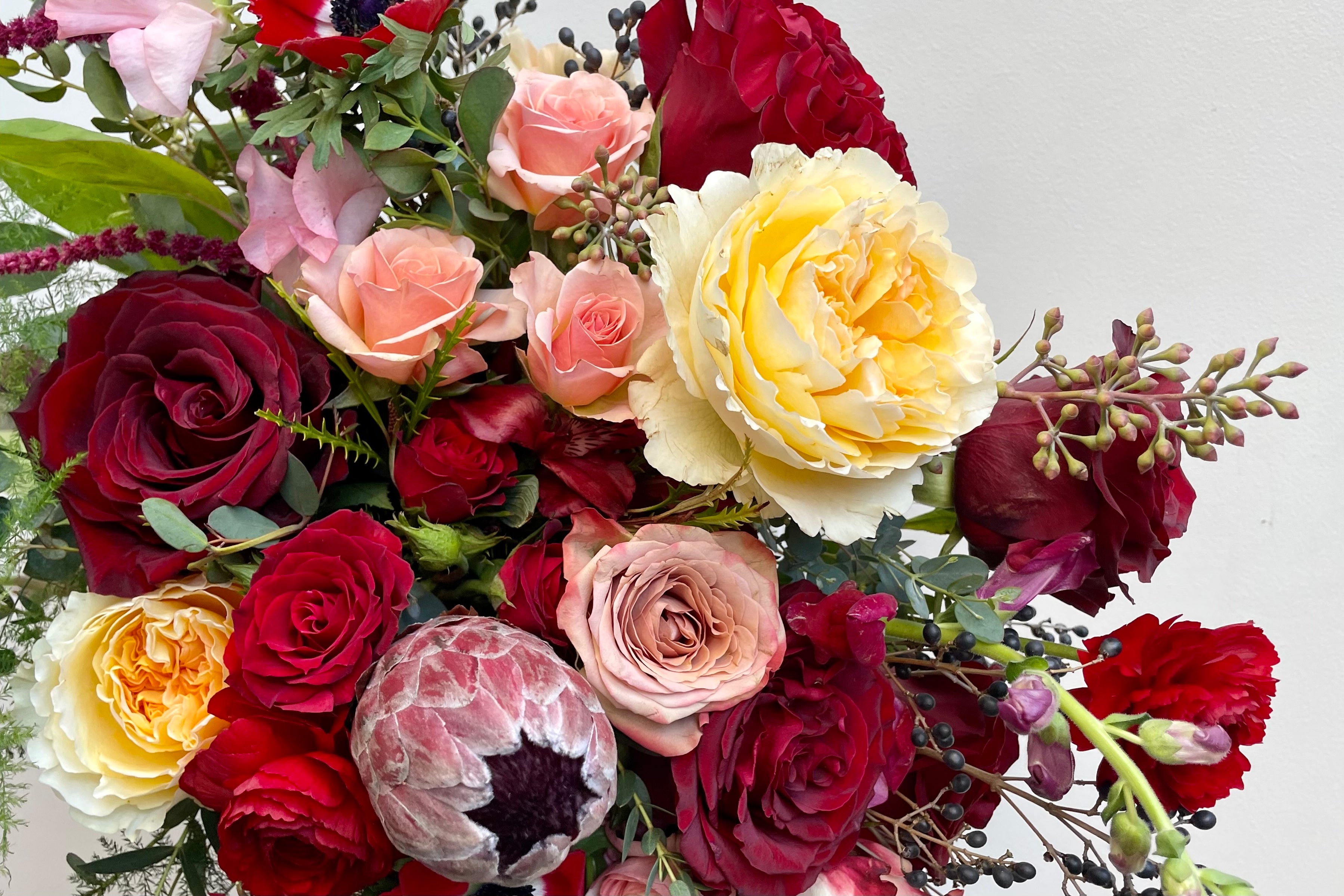 Floral arrangement for Valentines day in shades of red, nude and gold by Sprout Home.