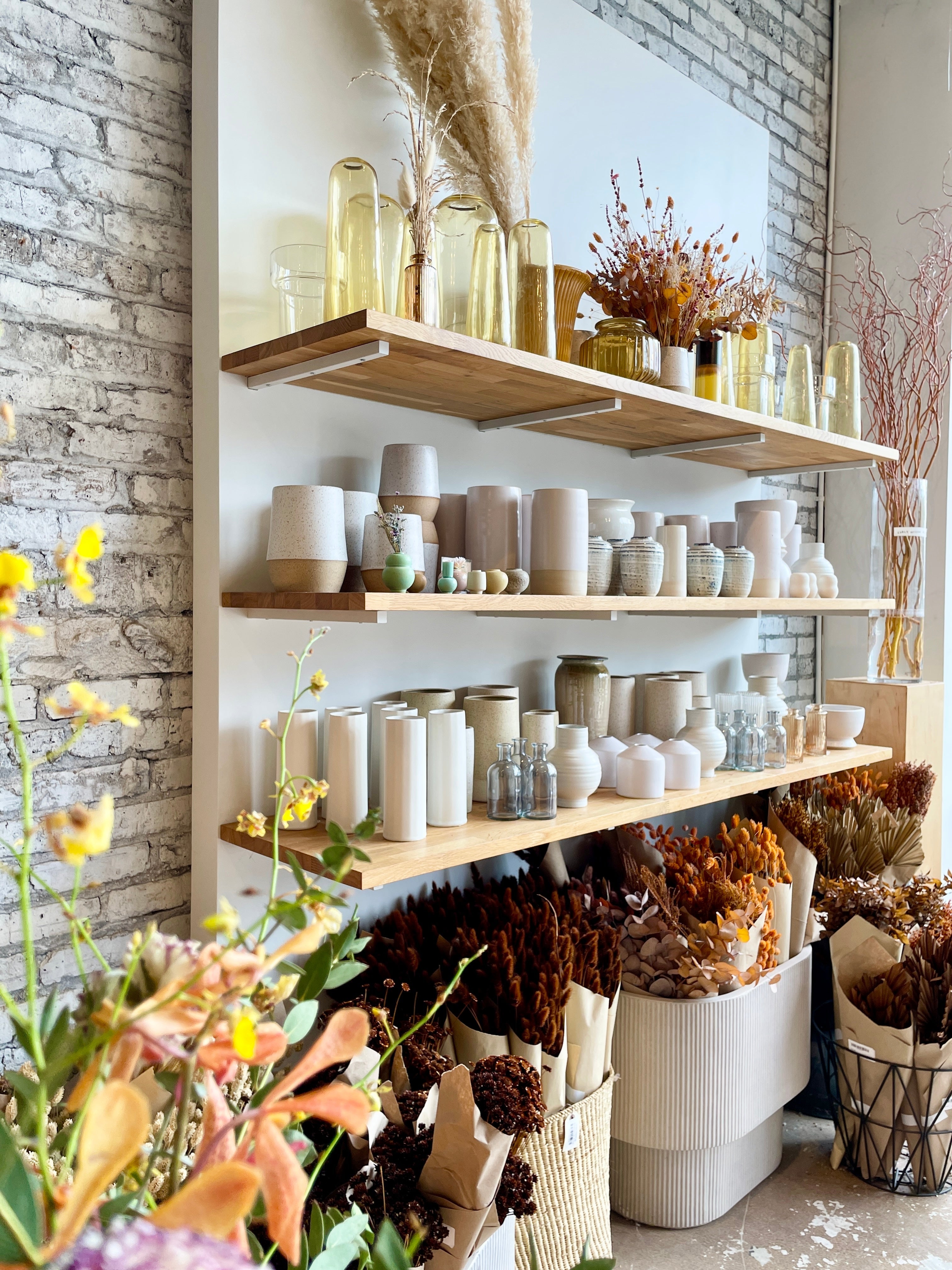 One of Sprout Home Floral walls with a collection of spring colored vases. www.sprouthome.com