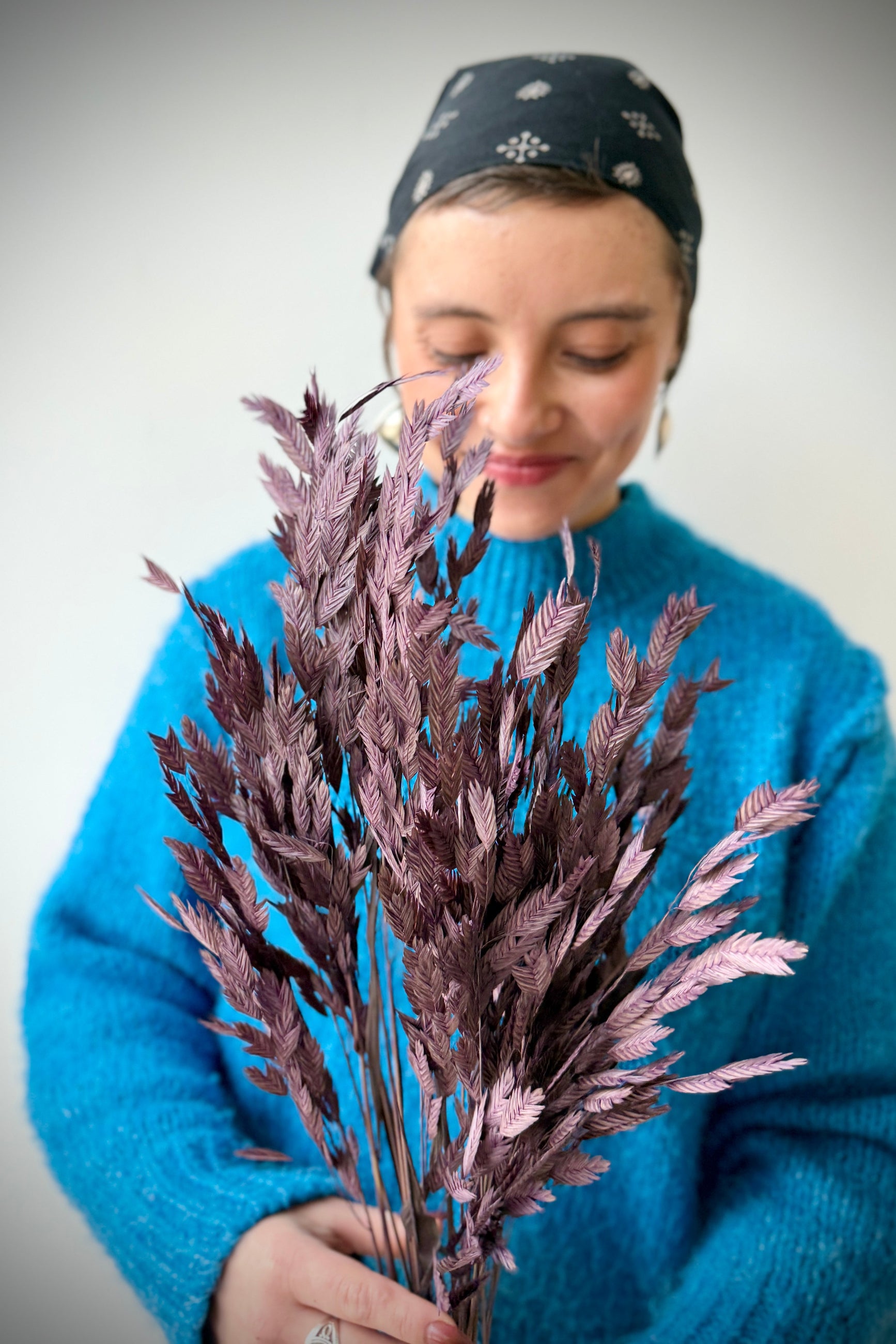 Person holding a bouquet of dried Chasmanthium against a plain background ©Sprout Home