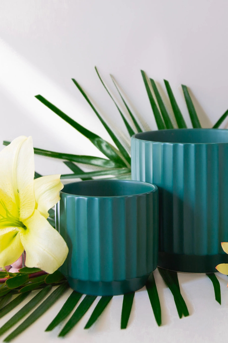 Two Rainforest green planters with a pineapple and flowers on a white background ©Jungle Club
