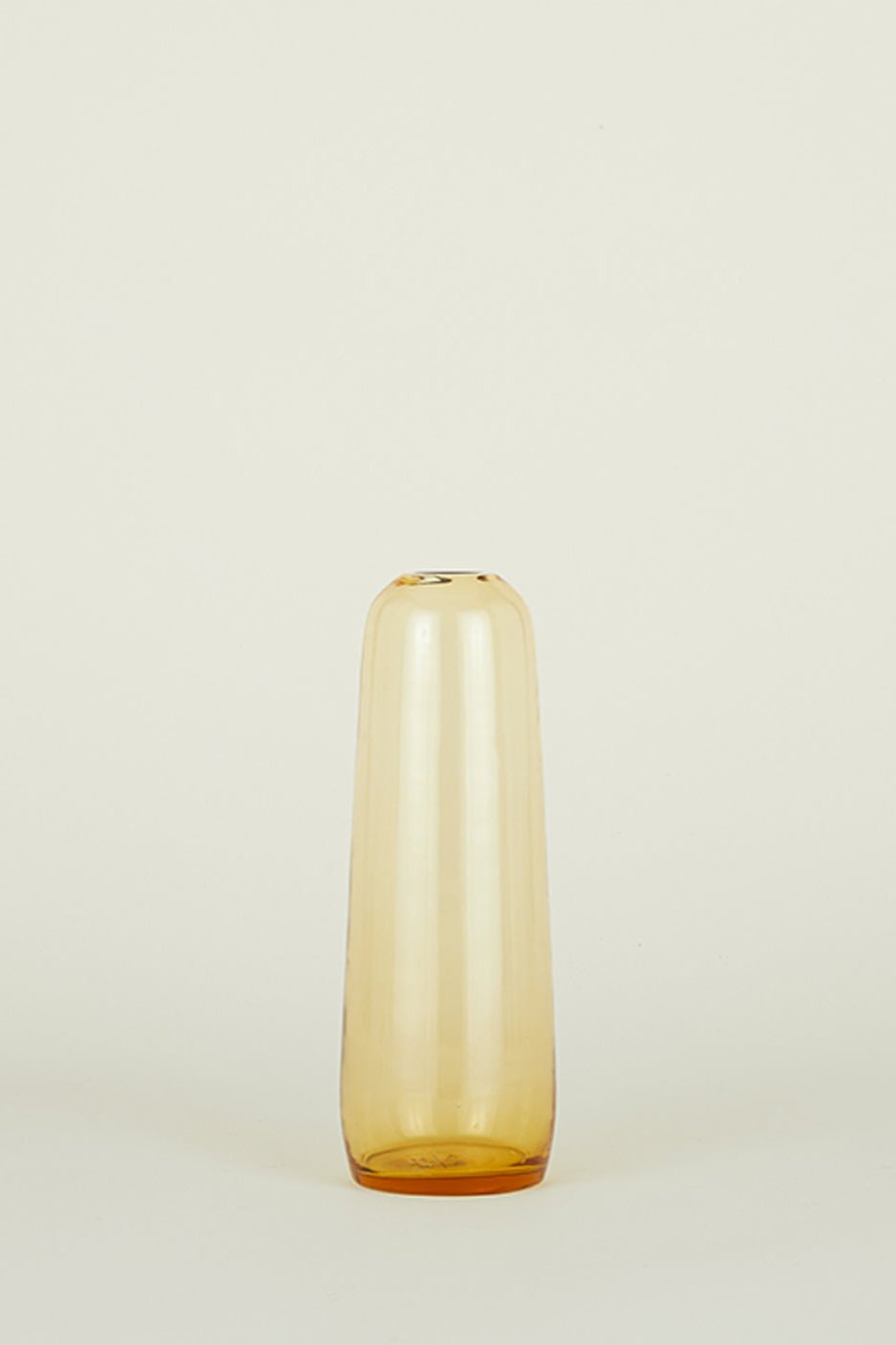 Aurora Pill vase in Amber Small by Hawkins New York shown t eye level from the side.