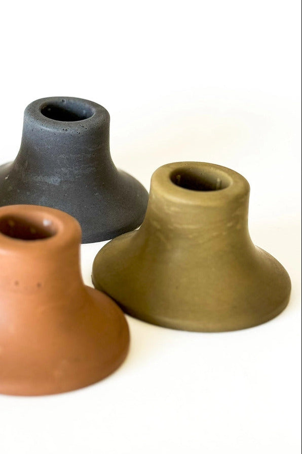Three concrete candle holders in different colors on a white background ©Sunday Nomad