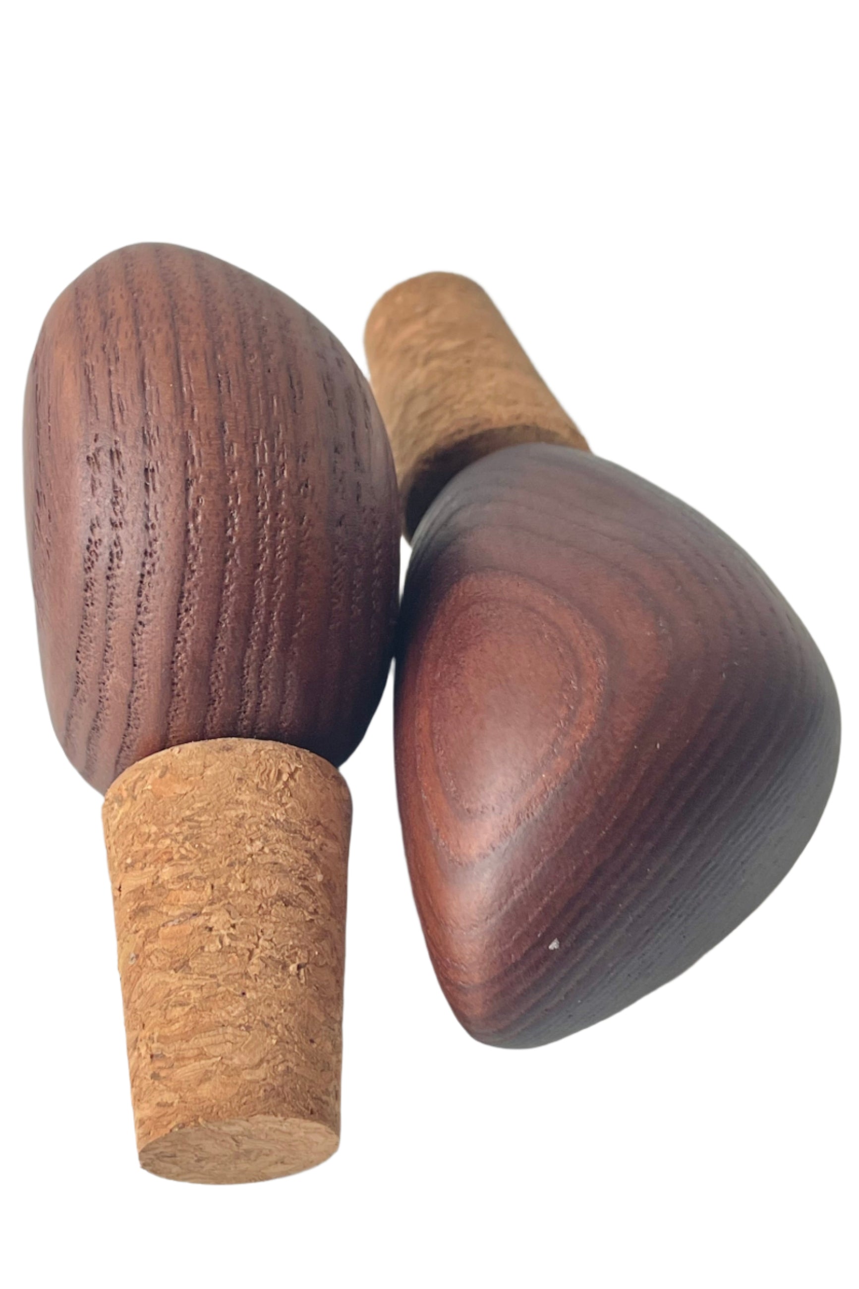 Photo of a pair of wood-topped cork bottle stoppers or wine stoppers. The warm wood tones and wood grain are visible. Shown on a white background ©Sprout Home