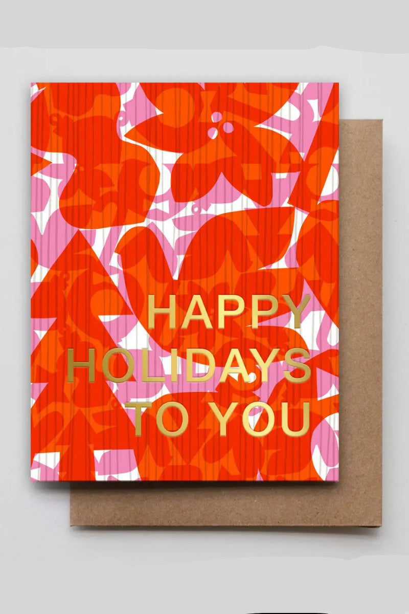 Holiday Icon Layers Card with a bold orange, pink, and white floral pattern and gold foil text reading 'HAPPY HOLIDAYS TO YOU,' shown with a brown envelope on a light gray background. ©Hammerpress