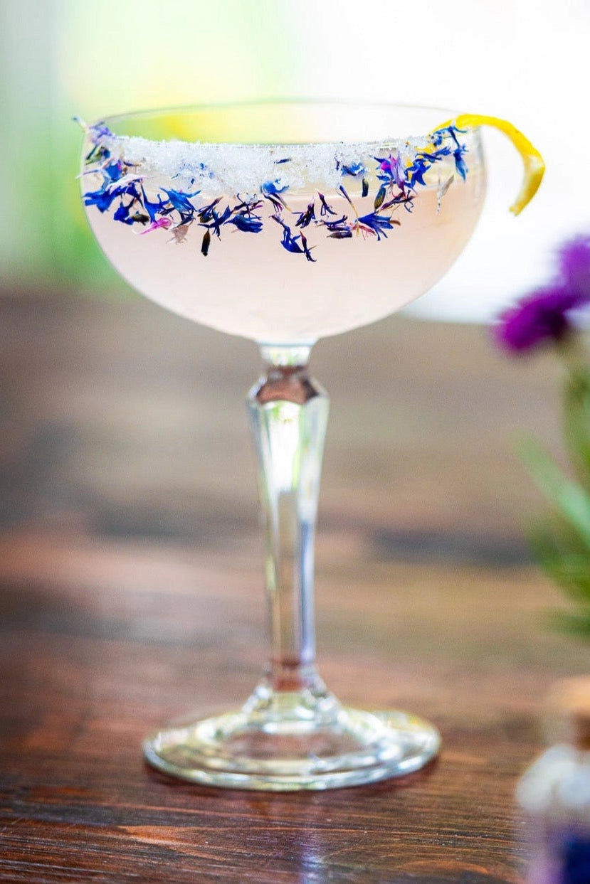 Cocktail in a decorative glass with floral sugar on a wooden table ©Flouwer Co.