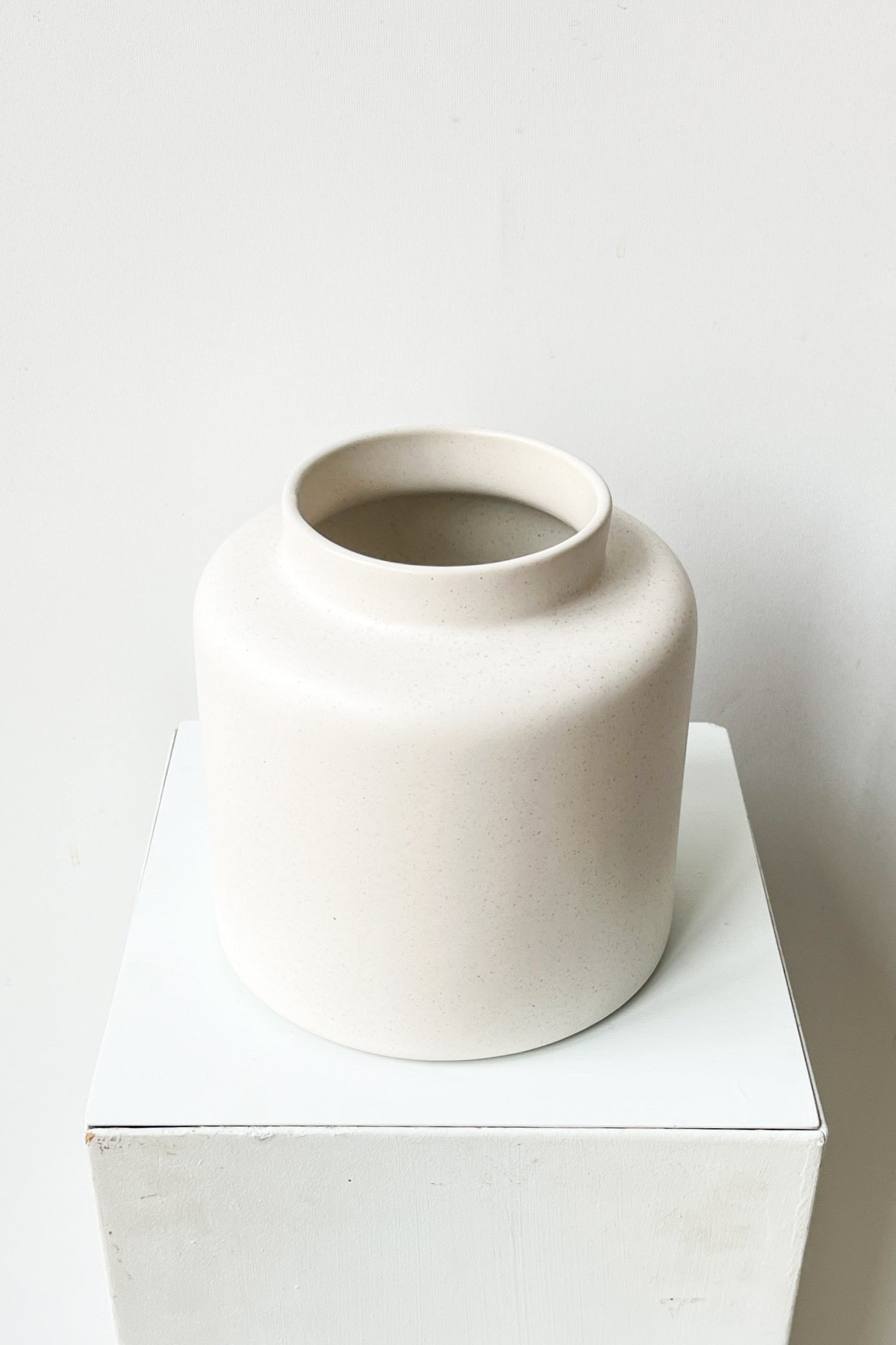 White ceramic vase on a white pedestal against a white background ©Sprout Home