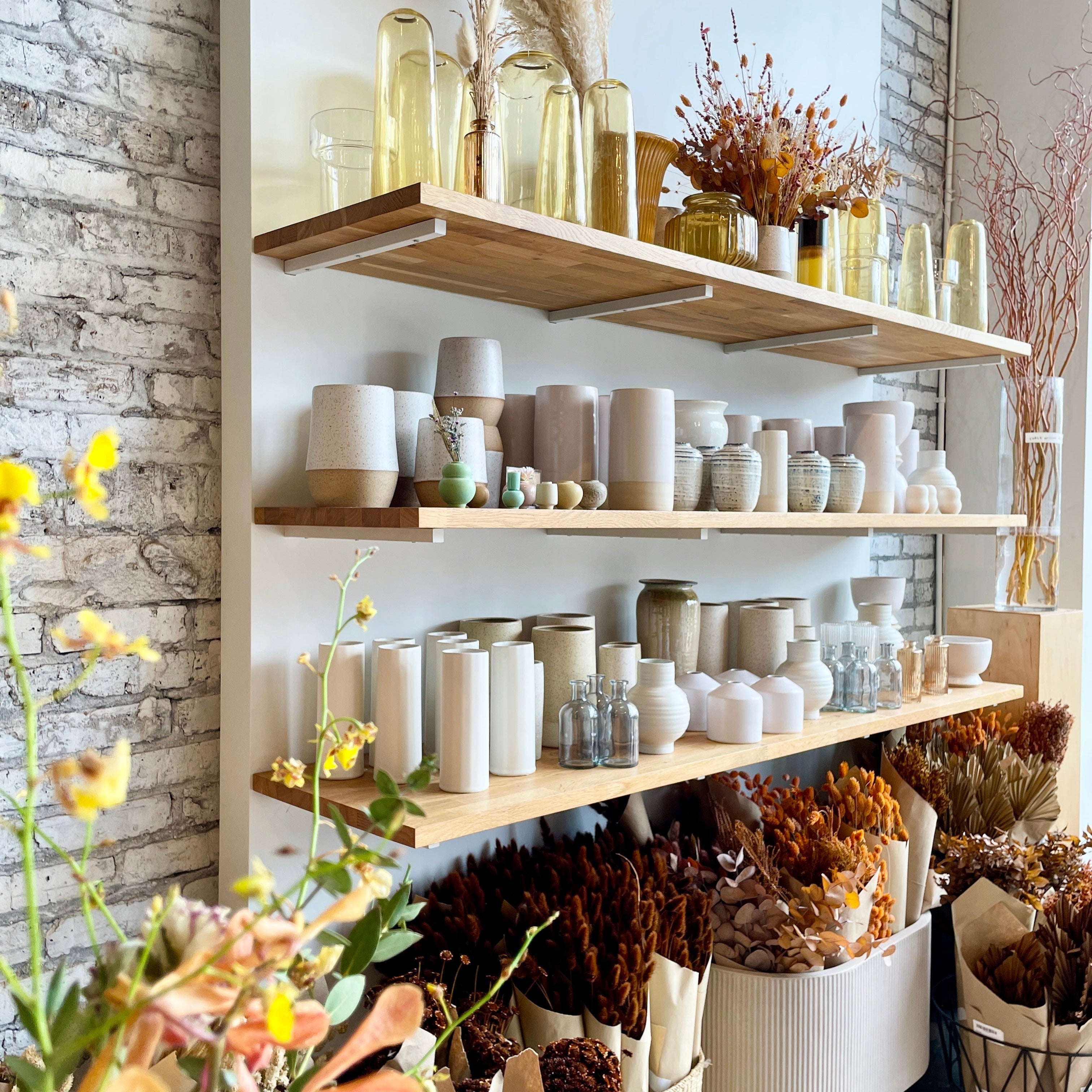 Image of the Sprout Home Floral store set of wall shelves with products on it and dried floral below.