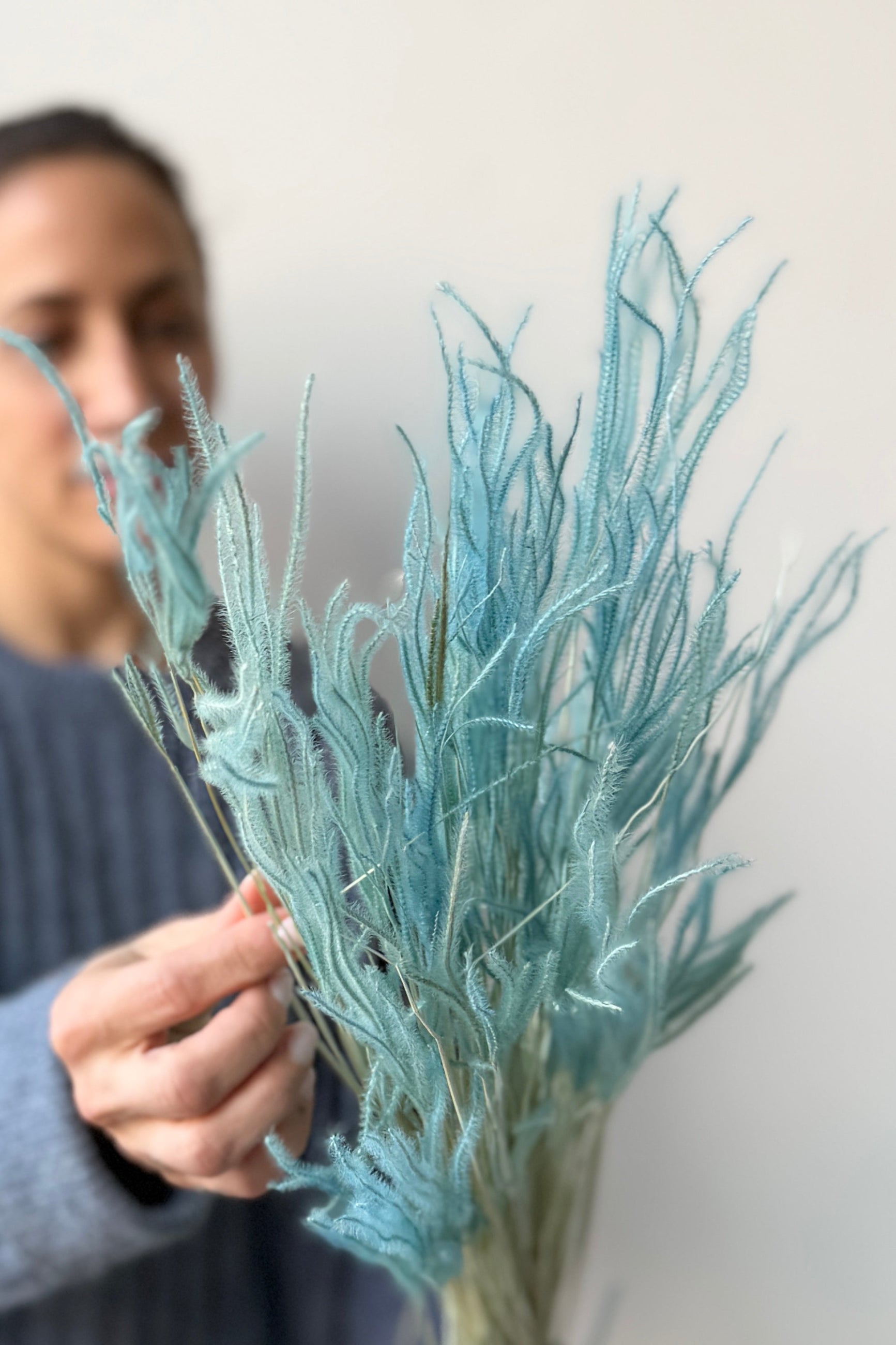 Person holding Ouro Teal Pastel Preserved Bunch against a white background ©Sprout Home