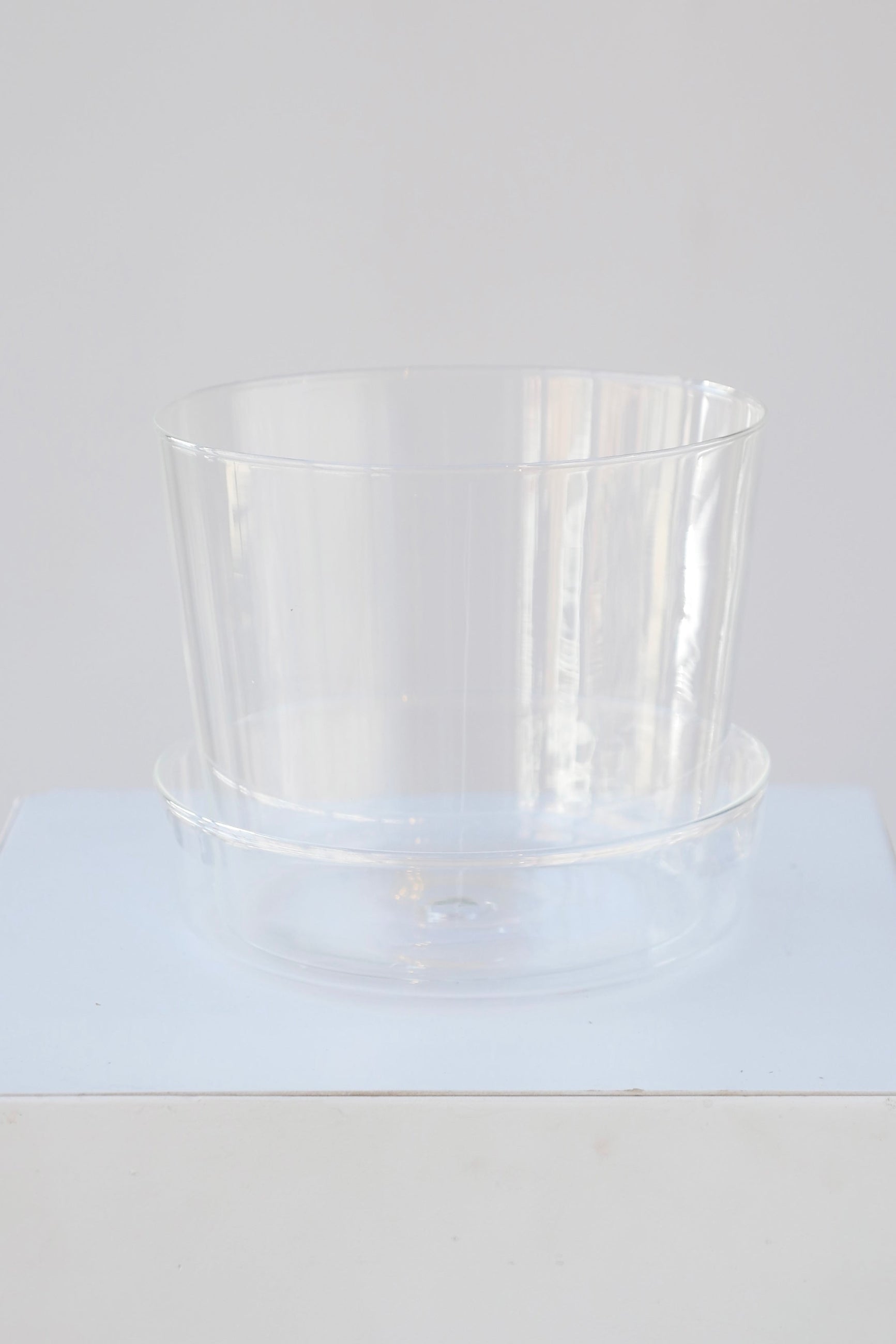 Glass pot and saucer shown from the top side blending in to the white background ©Sprout Home