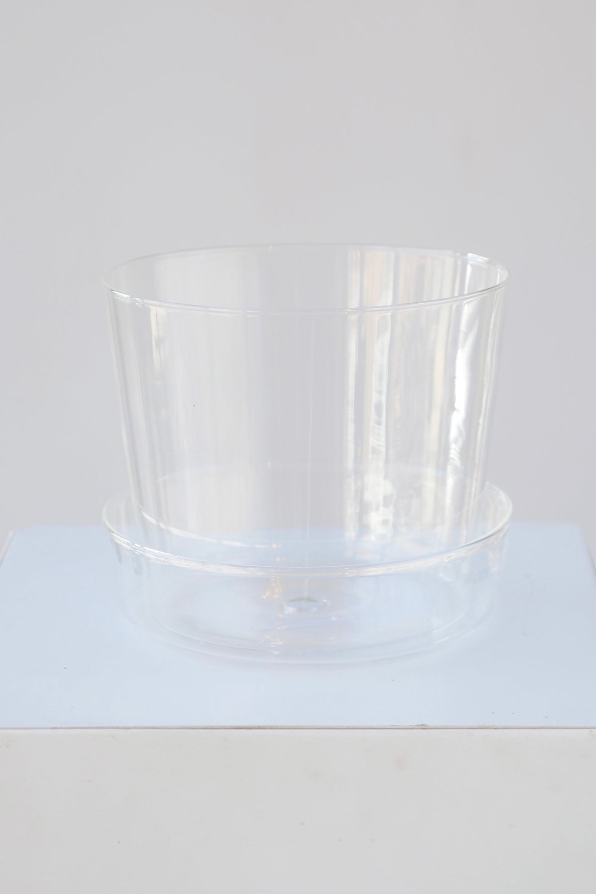 Glass pot and saucer shown from the top side blending in to the white background ©Sprout Home