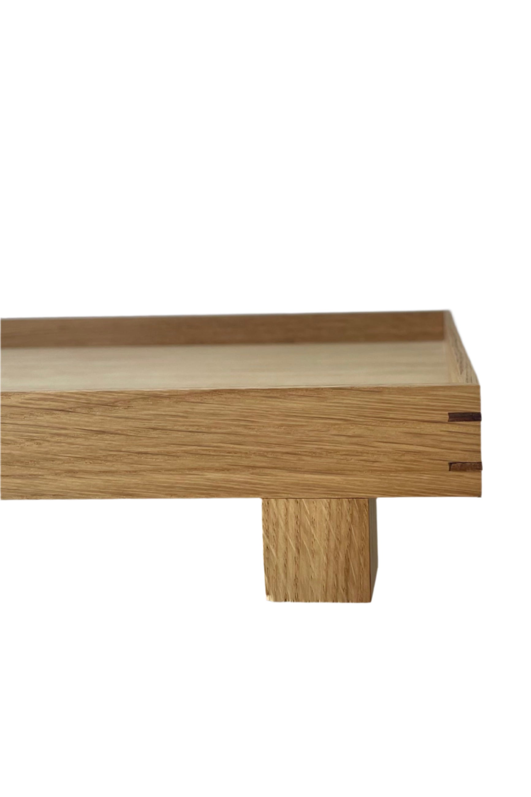 Close photo of a Ferm Living Bon Wooden Tray. A view of the corner detail, sides and leg of the tray is shown. ©Sprout Home