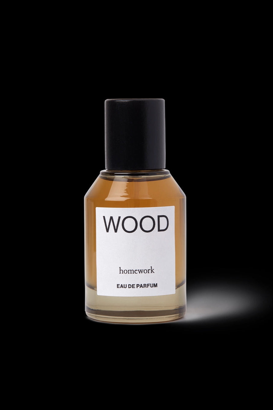 Wood Eau de Parfum Perfume bottle labeled 'WOOD' by 'homework' on a black background ©Homework