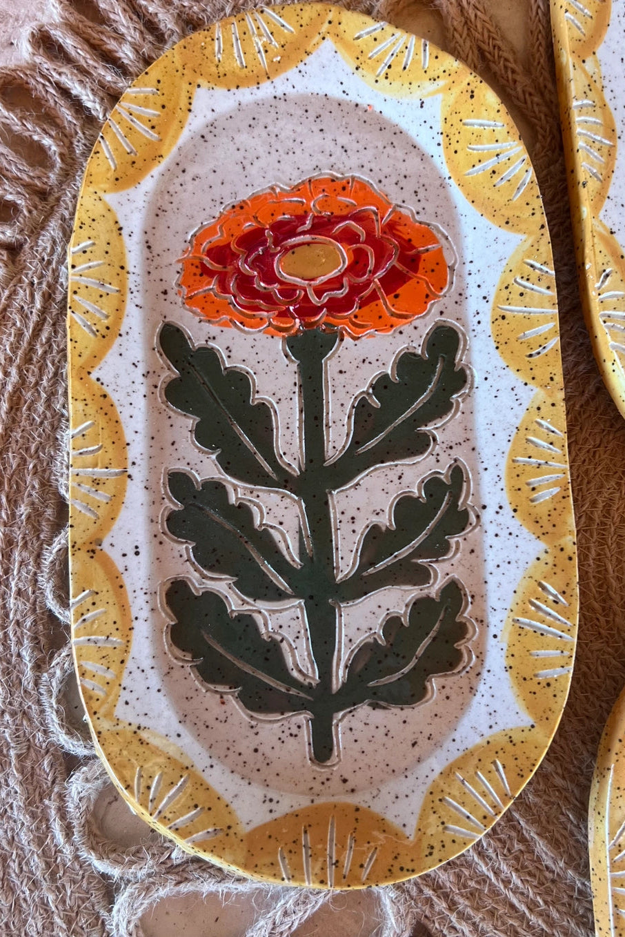Decorative Goldie Marigold ceramic plate with floral design on a textured surface ©Tough Kitty Design