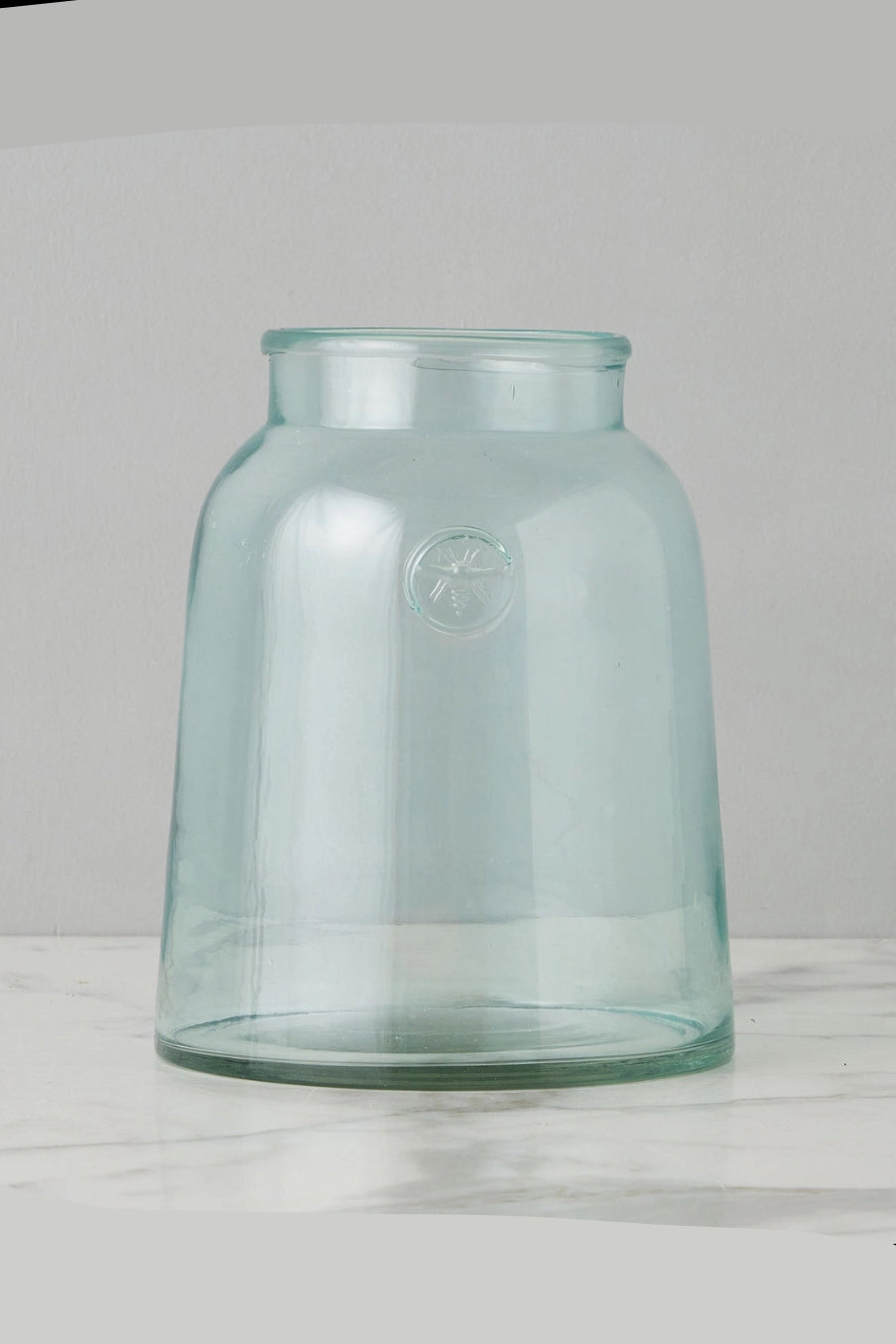 Clear glass Bee jar on a light wooden surface with a gray background ©Etu Home
