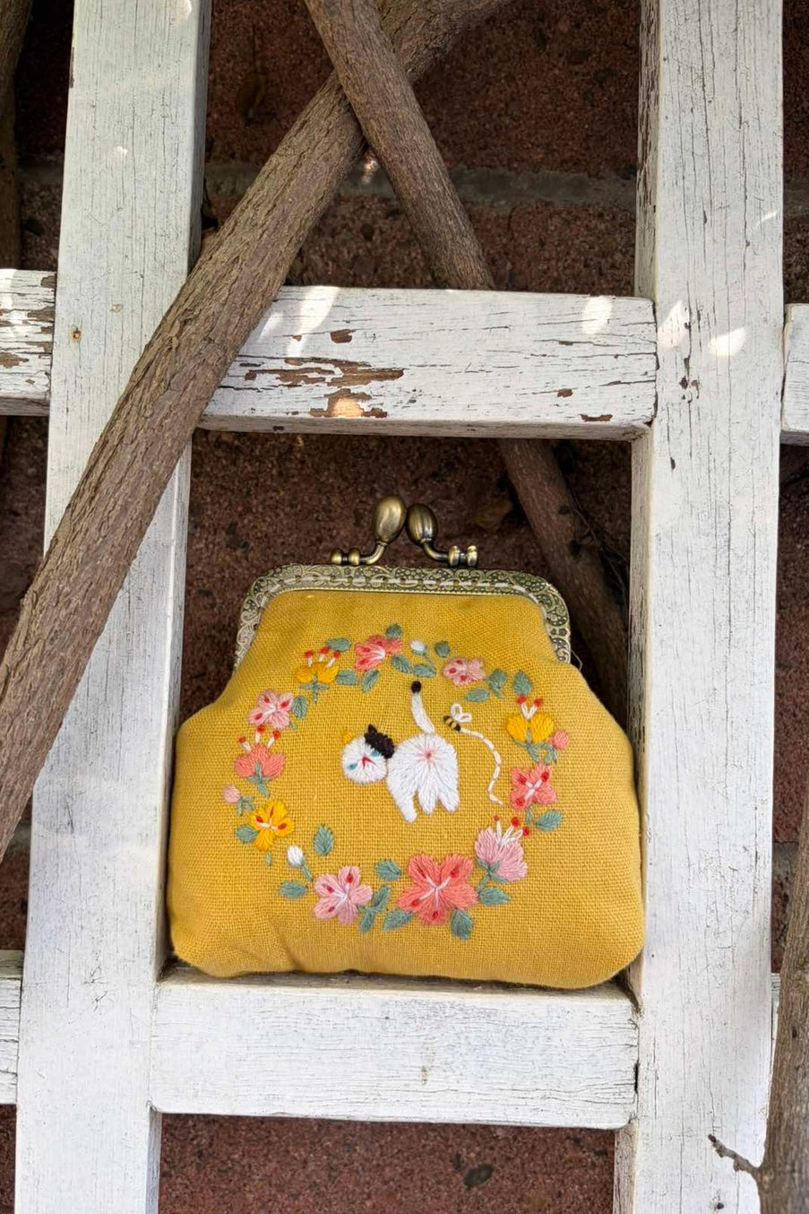Cat Embroidered Coin Purse sitting on a wood fence ©Quince Fables