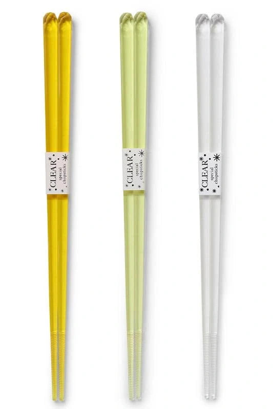 Three different colored acrylic chopstick pairs, one clear, one light yellow and one dark yellow.