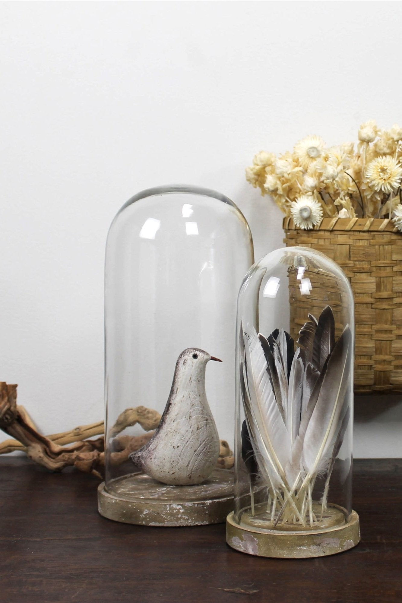 Large Castello Dome next to a smaller one by Homeart. Each with items for displaying them and a wicker wall basket with flowers on the wall.