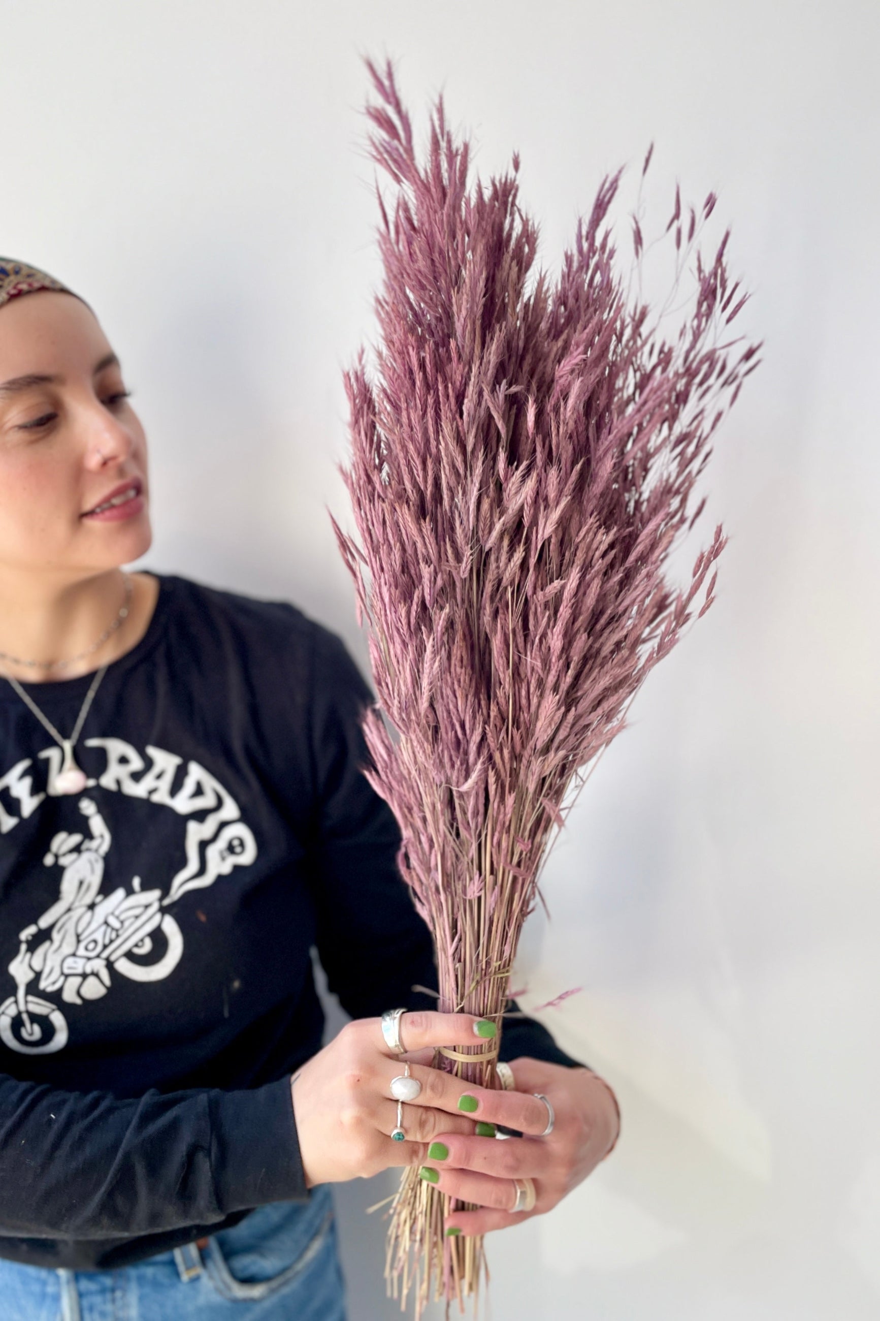 Plum Colored and preserved Bromus Mini at SPROUT HOME being held in hand by a sprout home staff member.