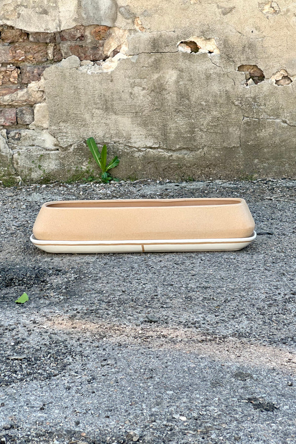 The dublin planter shown empty sitting on a concrete surface. 