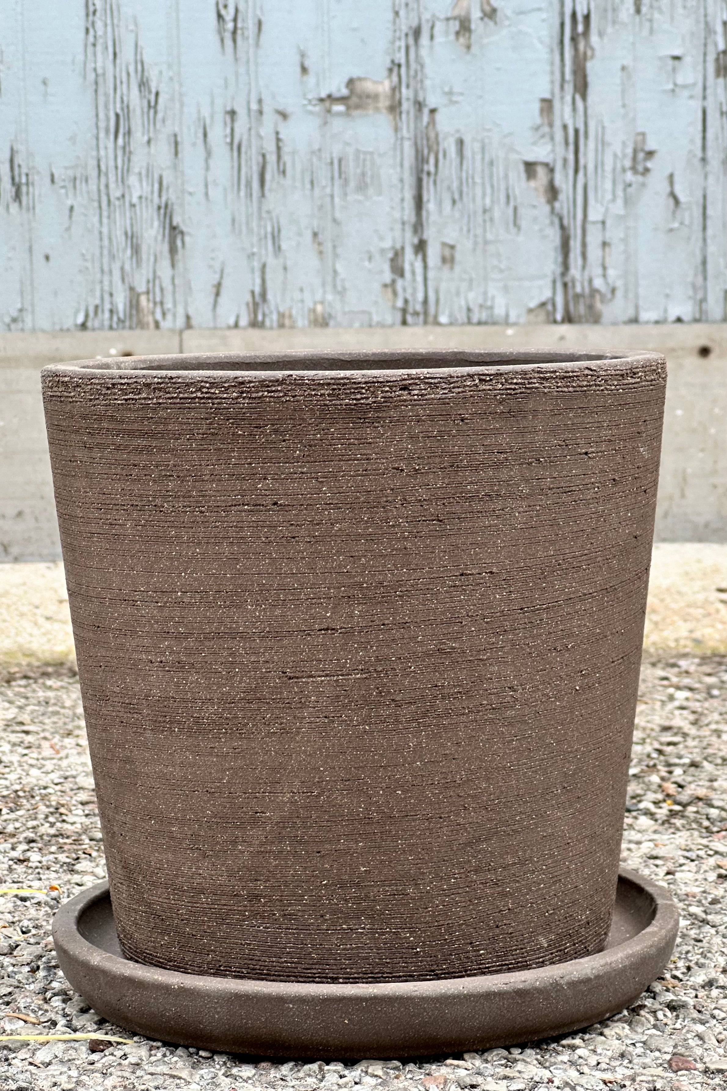 The medium size Maracay Carob colored planter in medium shown from the side with its etching.