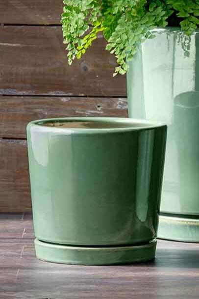 small /O 2 cylinder pot in Sea green empty and against a wood wall.