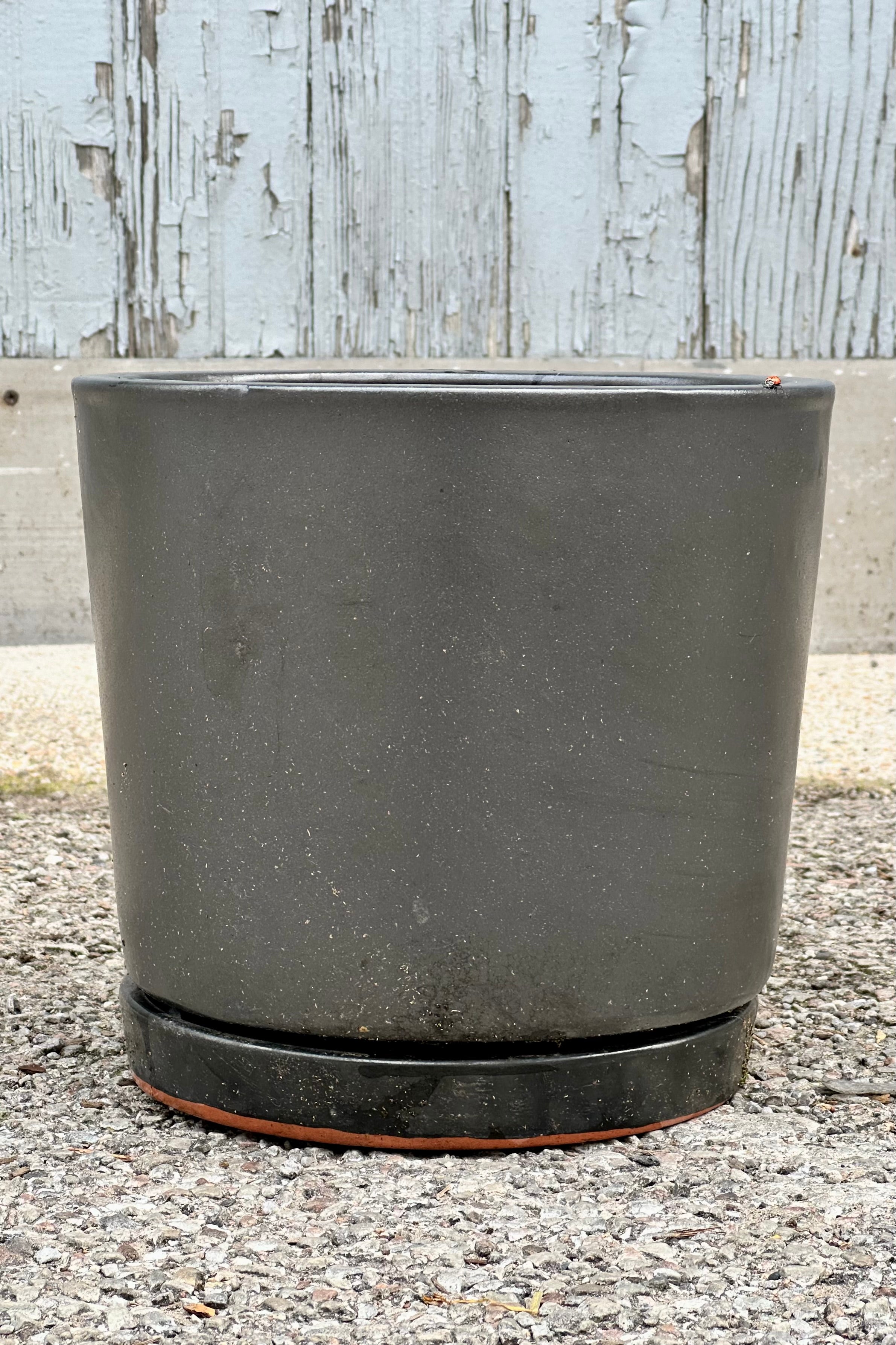 The I/O2 planter and saucer in a metallic gray Graphite finish viewed from the side.