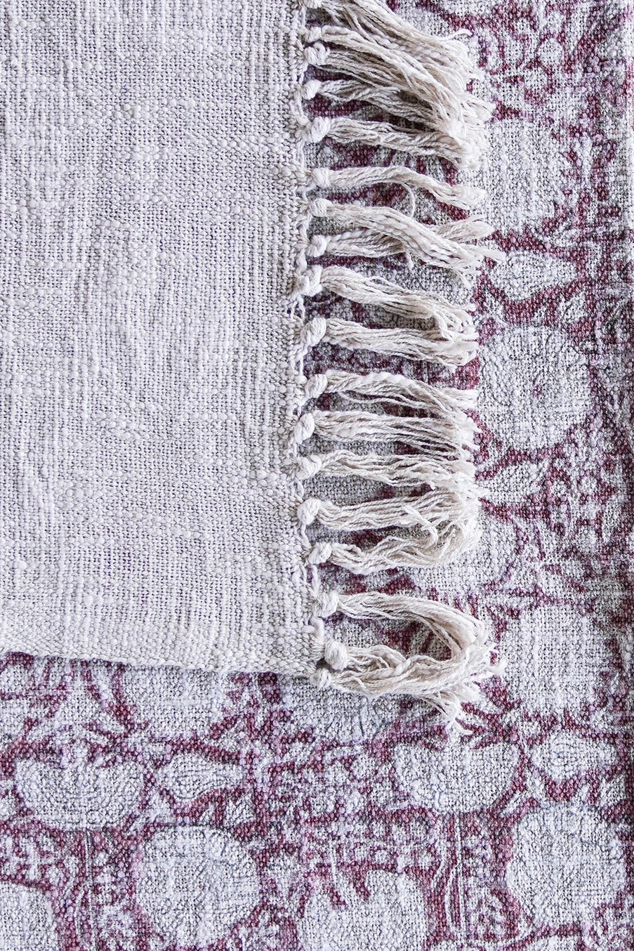 Close-up of a textured fabric with purple pattern and white fringe ©Blue Ocean Traders