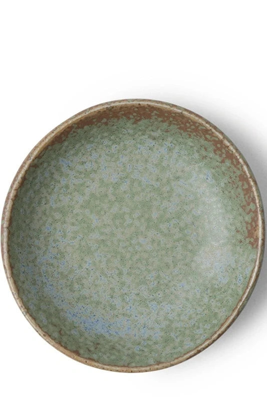 Terra Green saucer dish shown from the top against a white wall.