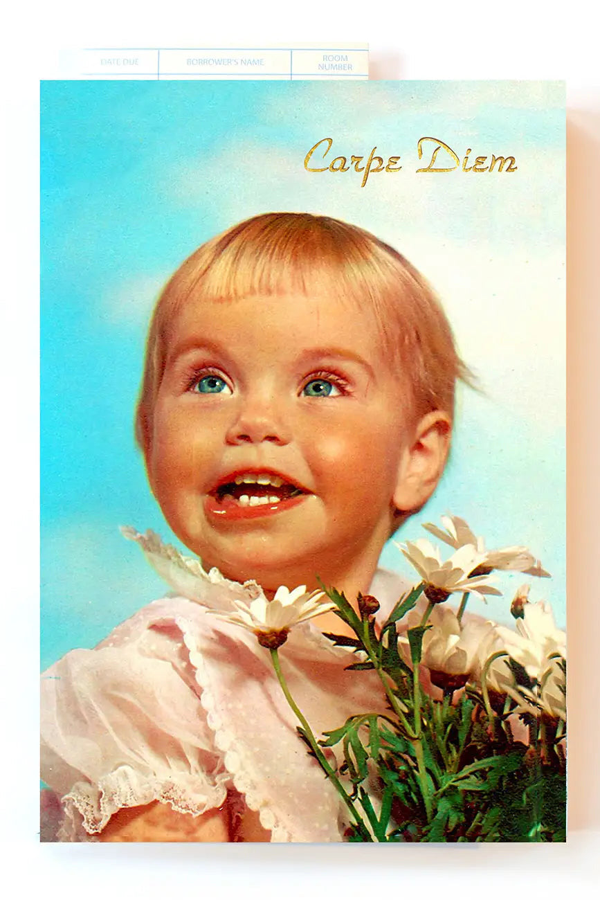 A vintage-style Carpe Diem Notebook featuring a young blonde child in a white dress holding white flowers against a light blue background, with the words 'Carpe Diem' printed at the top.