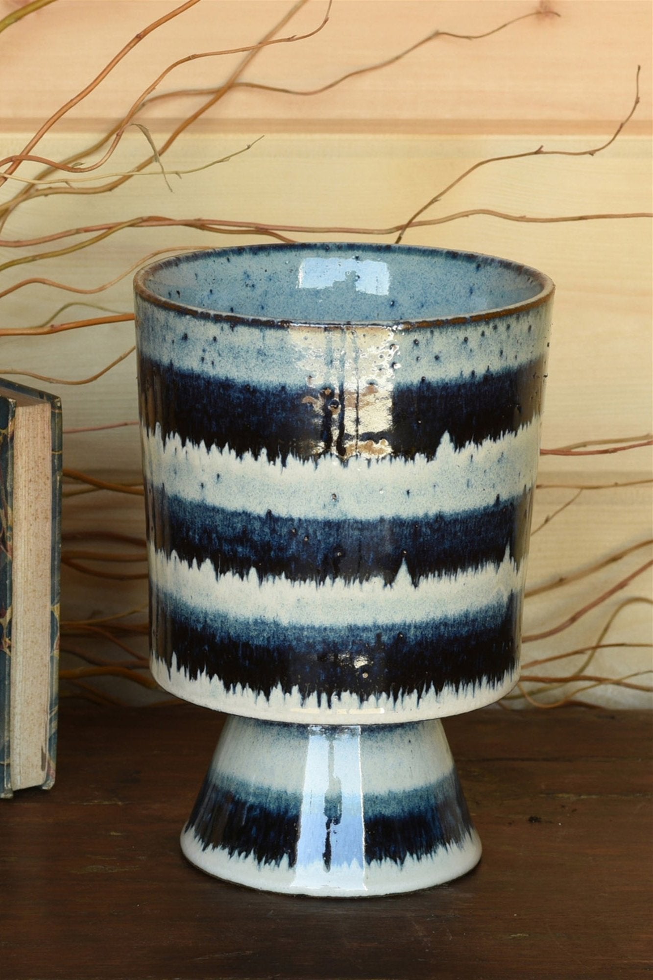 Toku CHalice vase by Homart. Empty and against a wood wall.