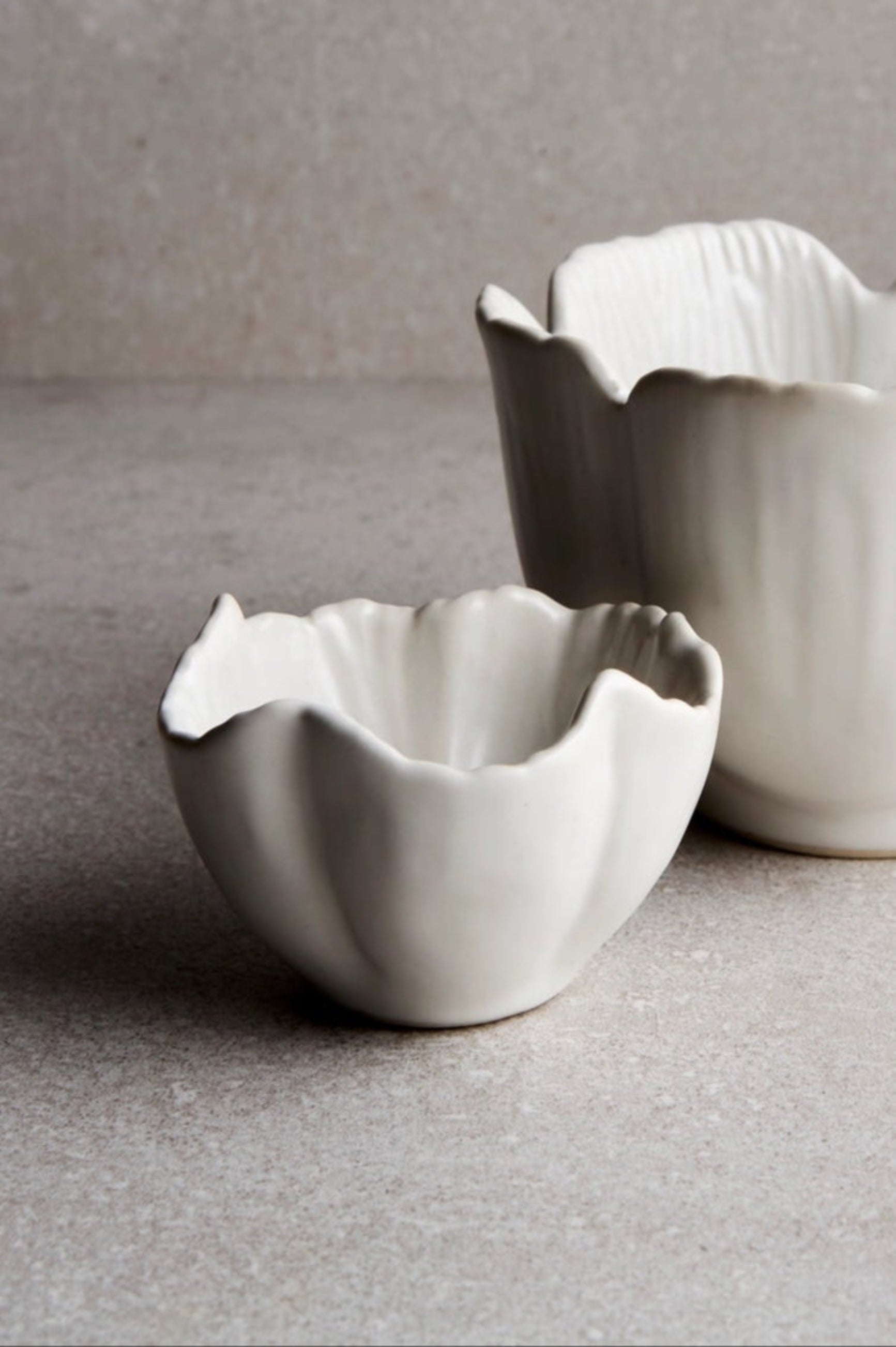 Small Petal bowl in front of a large petal bowl with a gray background and floor ©Goodies