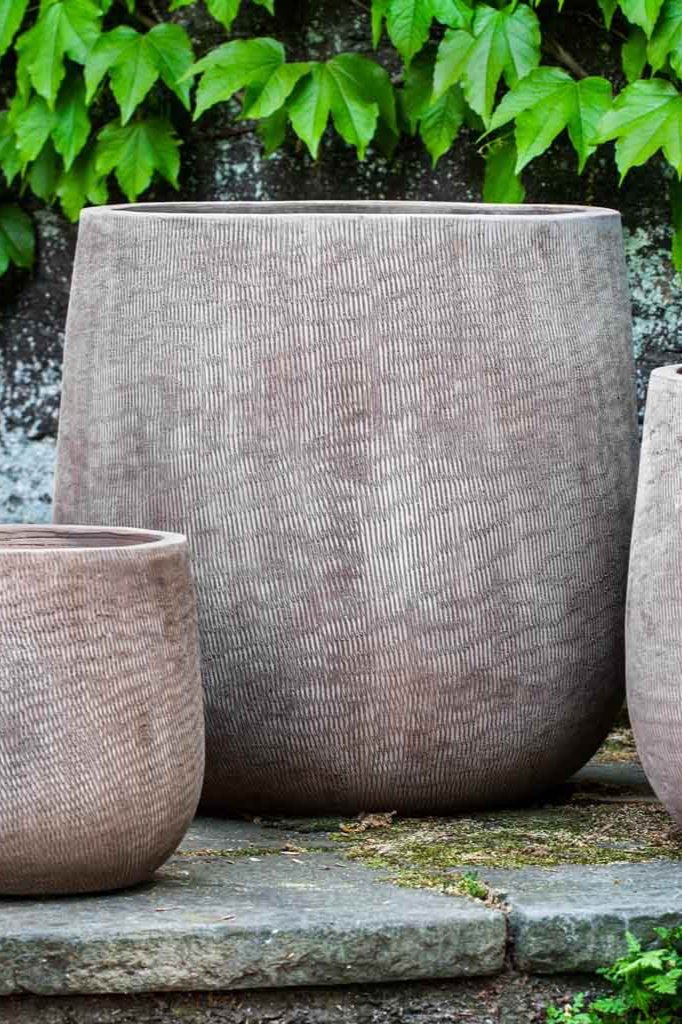 Large Antico terra cotta planter with a different sized antico planter on each size. All empty with vines above.