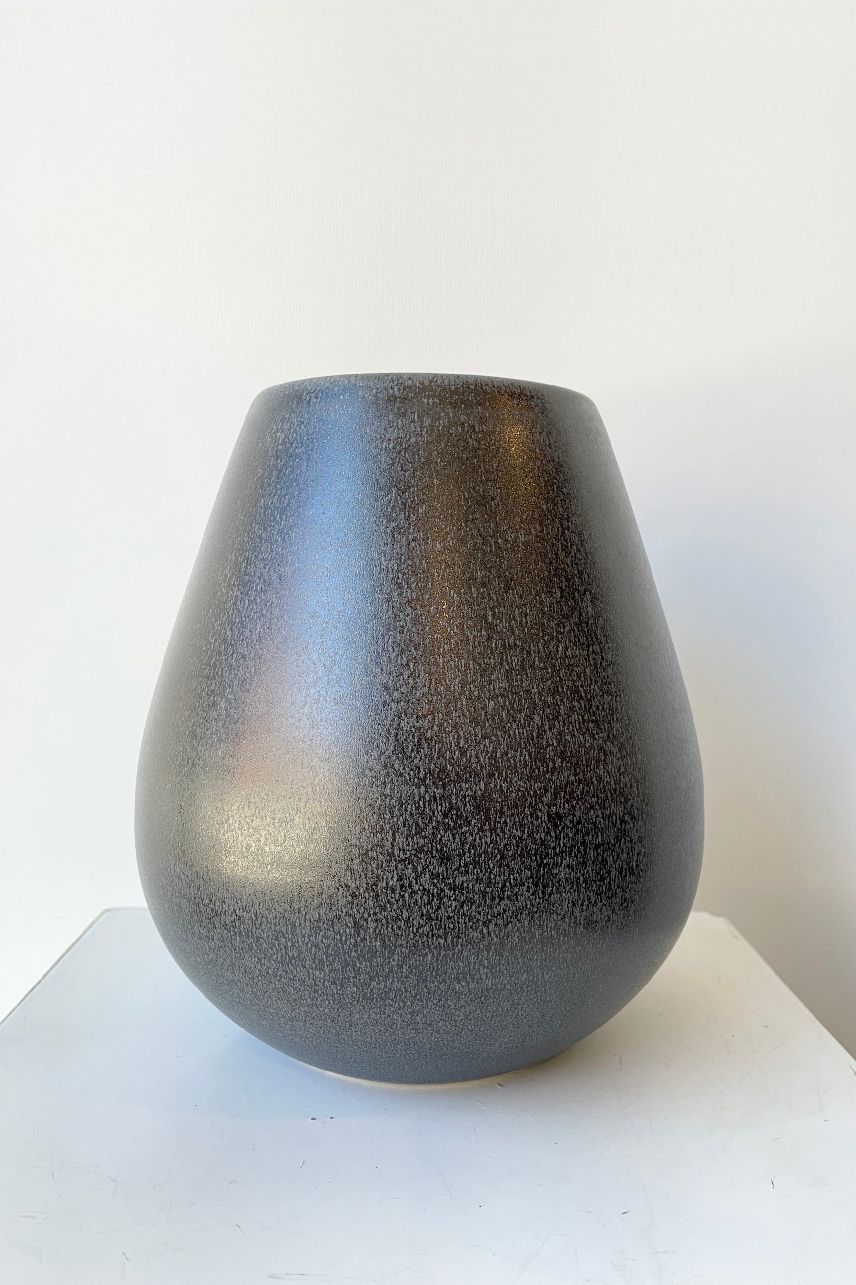The Round Ease Vase in a Black Iron color shown at eye level. ©Sprout Home