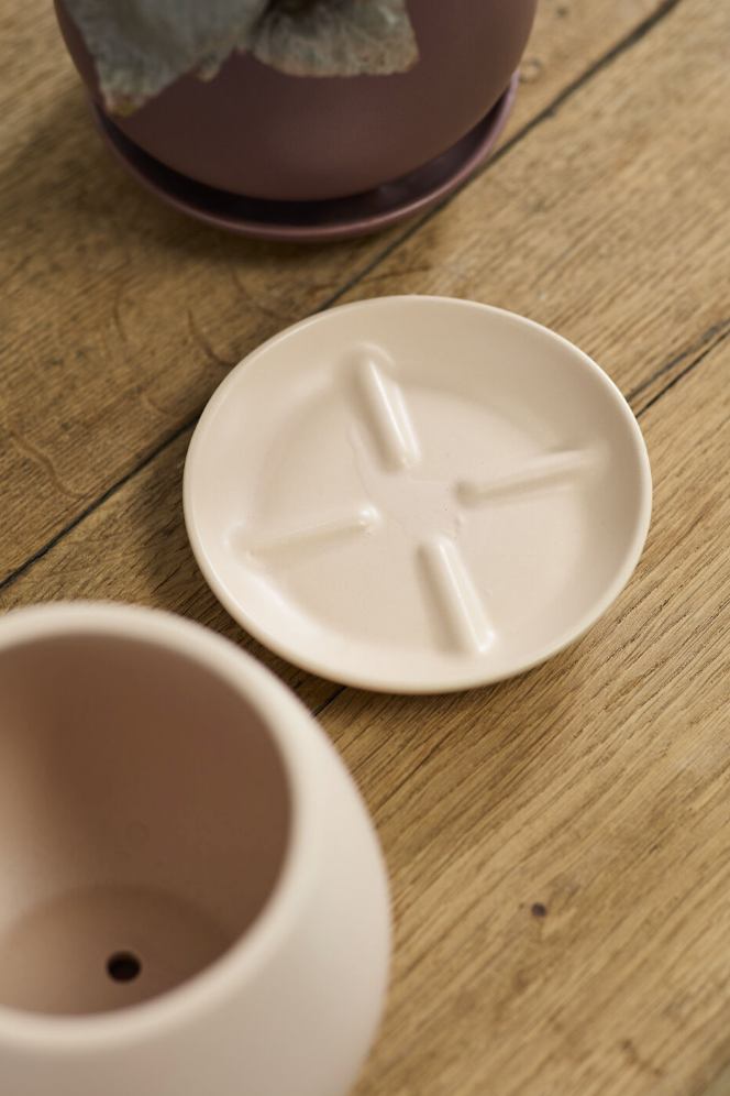 A ceramic pot and saucer on a wooden table ©Accent Decor
