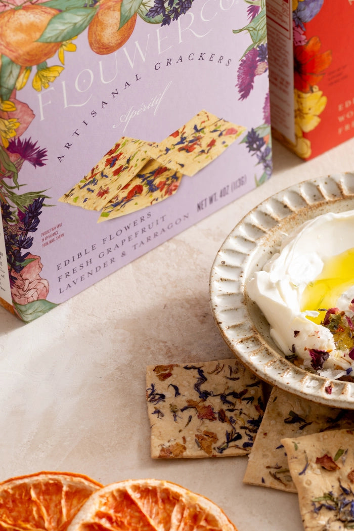 Yogurt dish with crackers and decorative elements on a table with branded boxes in the background. ©Flouwer Co.