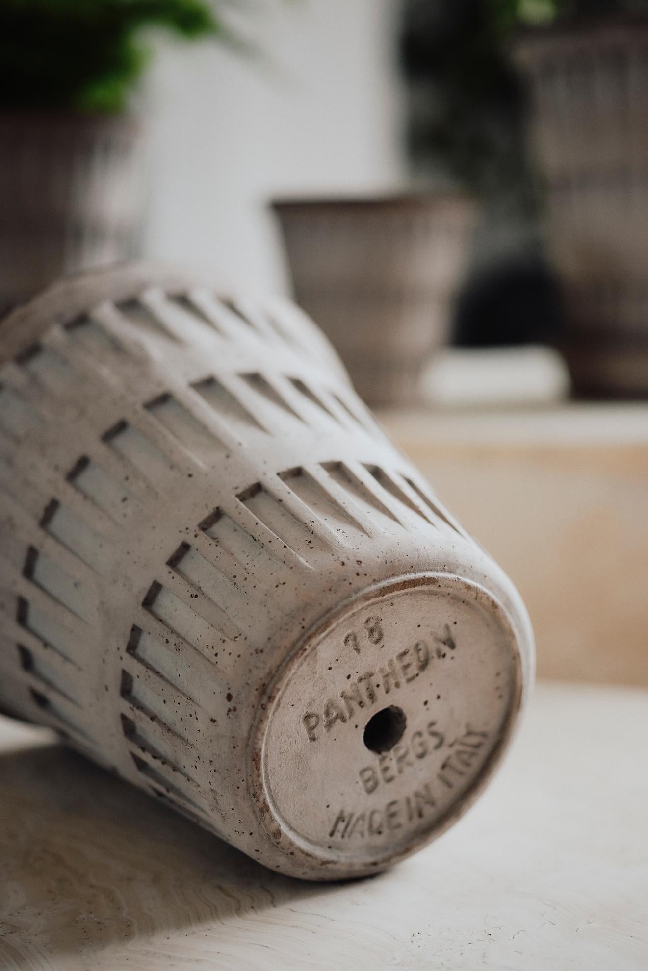 Ceramic gray Pantheon pot with lattice design and branding on a blurred background ©Bergs Potter