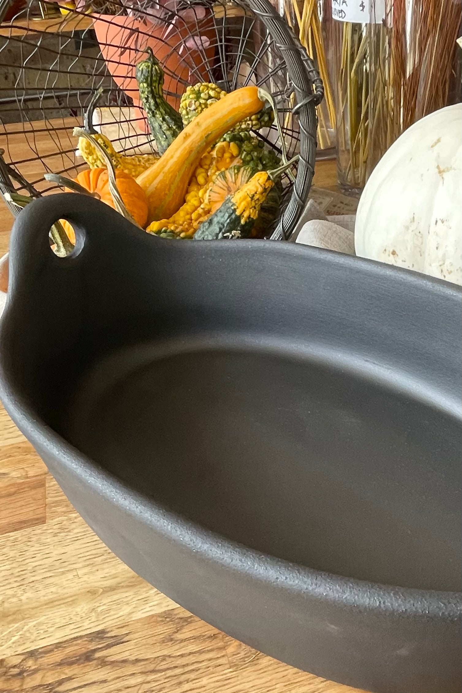 The Large Barro Oval Roaster sitting on a wood table with mini gourds in the background,
