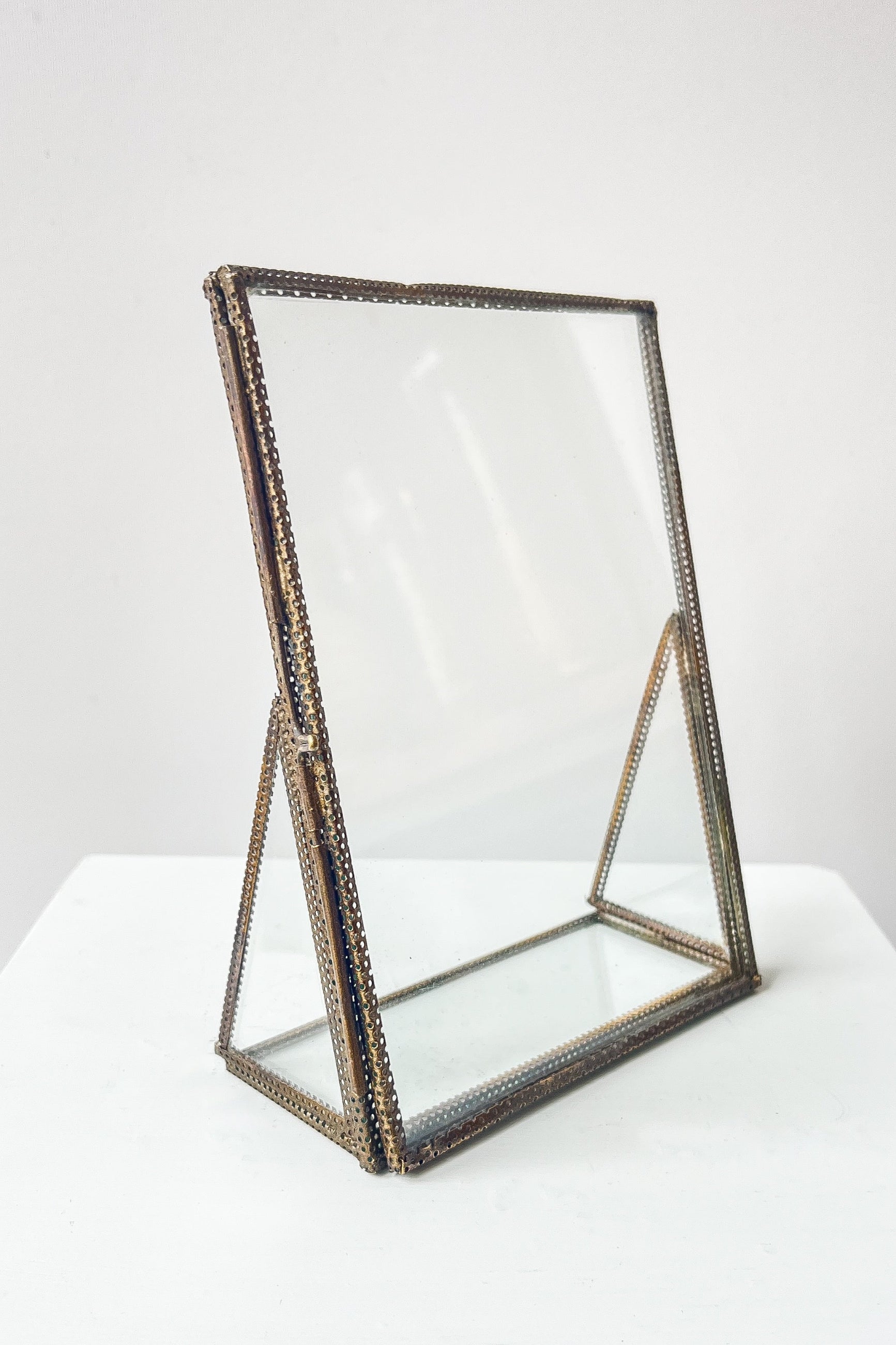 Decorative glass stand with metal frame on a white background ©Sprout Home