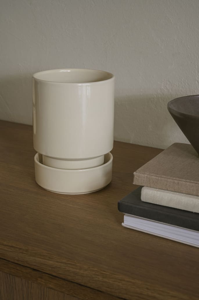 Beige ceramic planter on a wooden surface with book accents and a neutral background ©Bergs Potters
