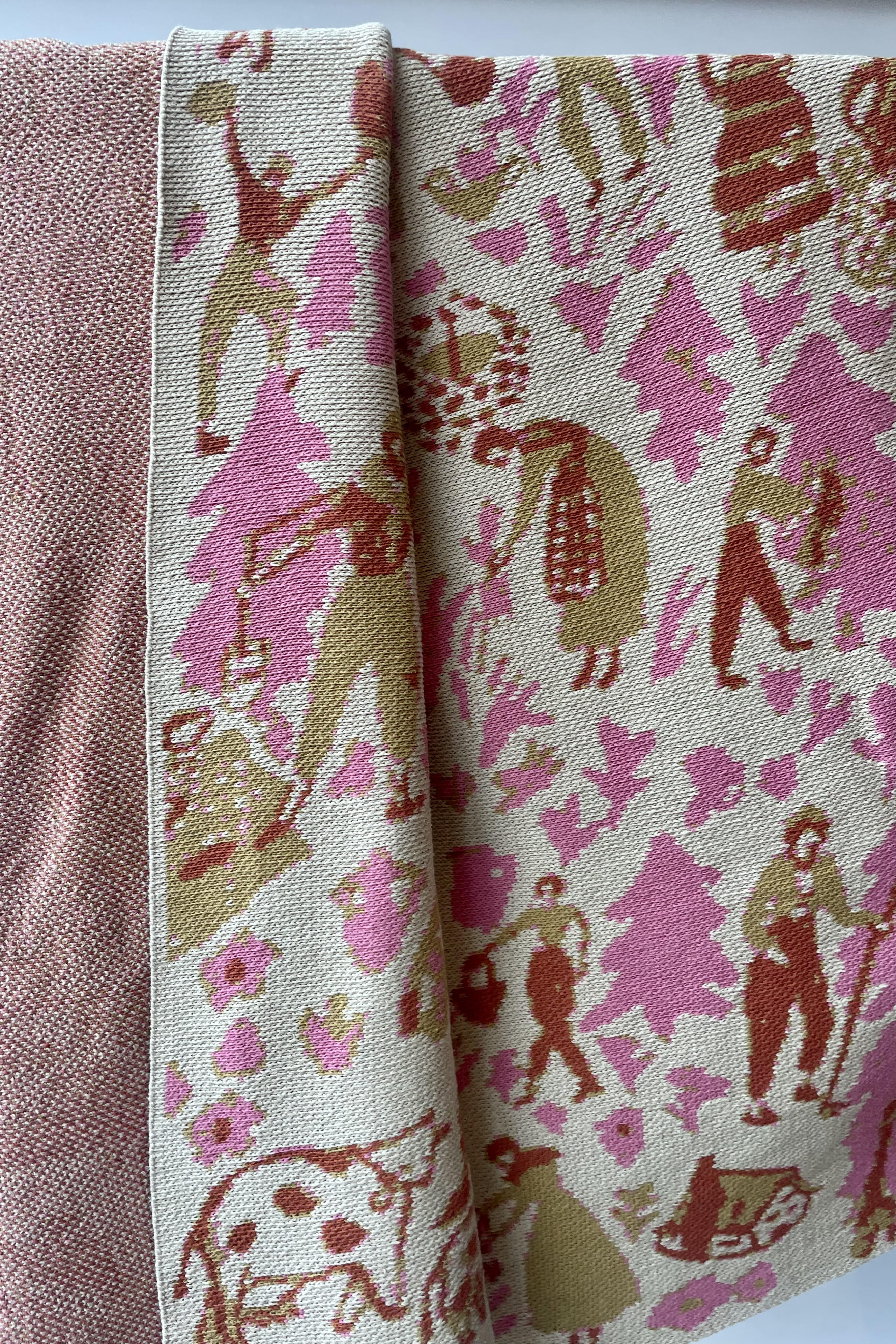Photo of front and back weave of Swiss Field pattern blanket against a white wall