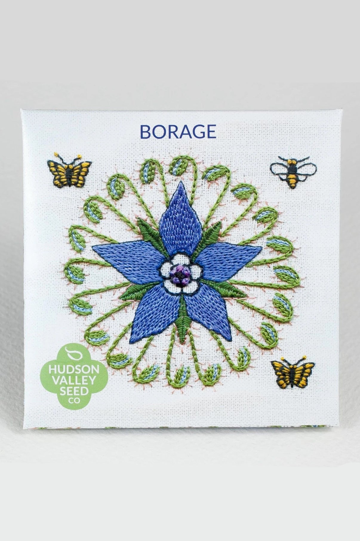 Embroidered borage flower with butterflies and a bee on Hudson Valley Seed Co. packaging. ©Hudson Valley Seed Co.