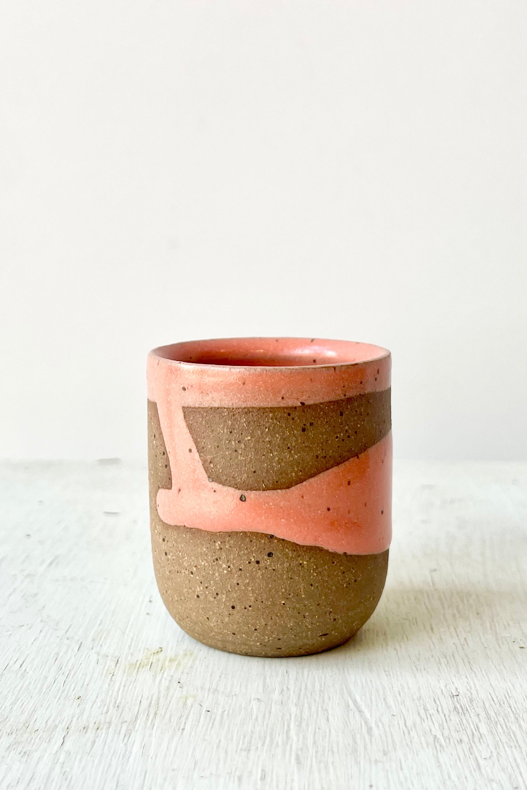 Ceramic cup with pink and brown design on a white background ©Sprout Home