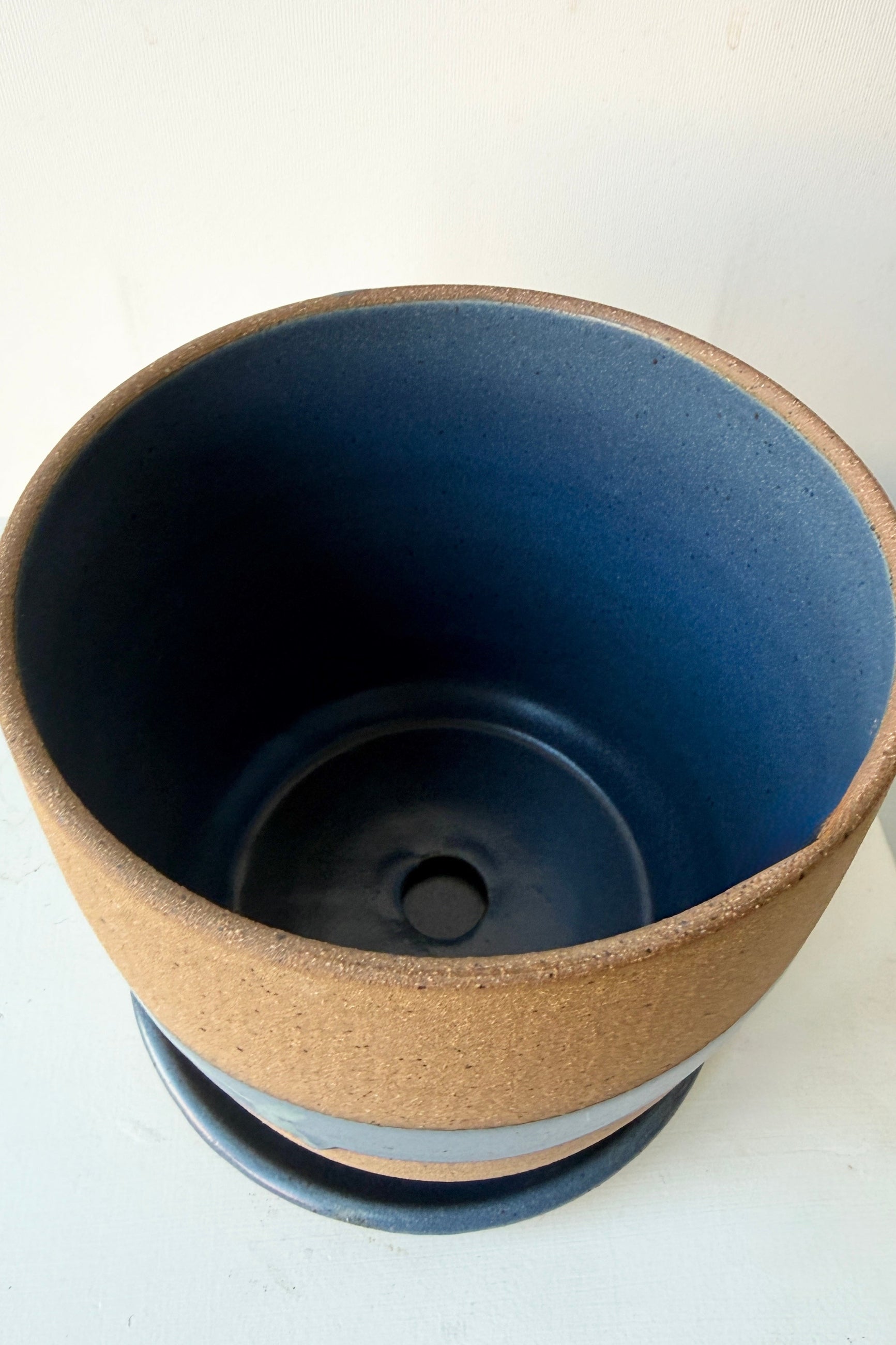 The inside denim colored glaze of the Cylinder Pot & Saucer Denim and Dark Teal Splash Glaze 4.5" by Christina Kosinski on a white background ©Sprout Home