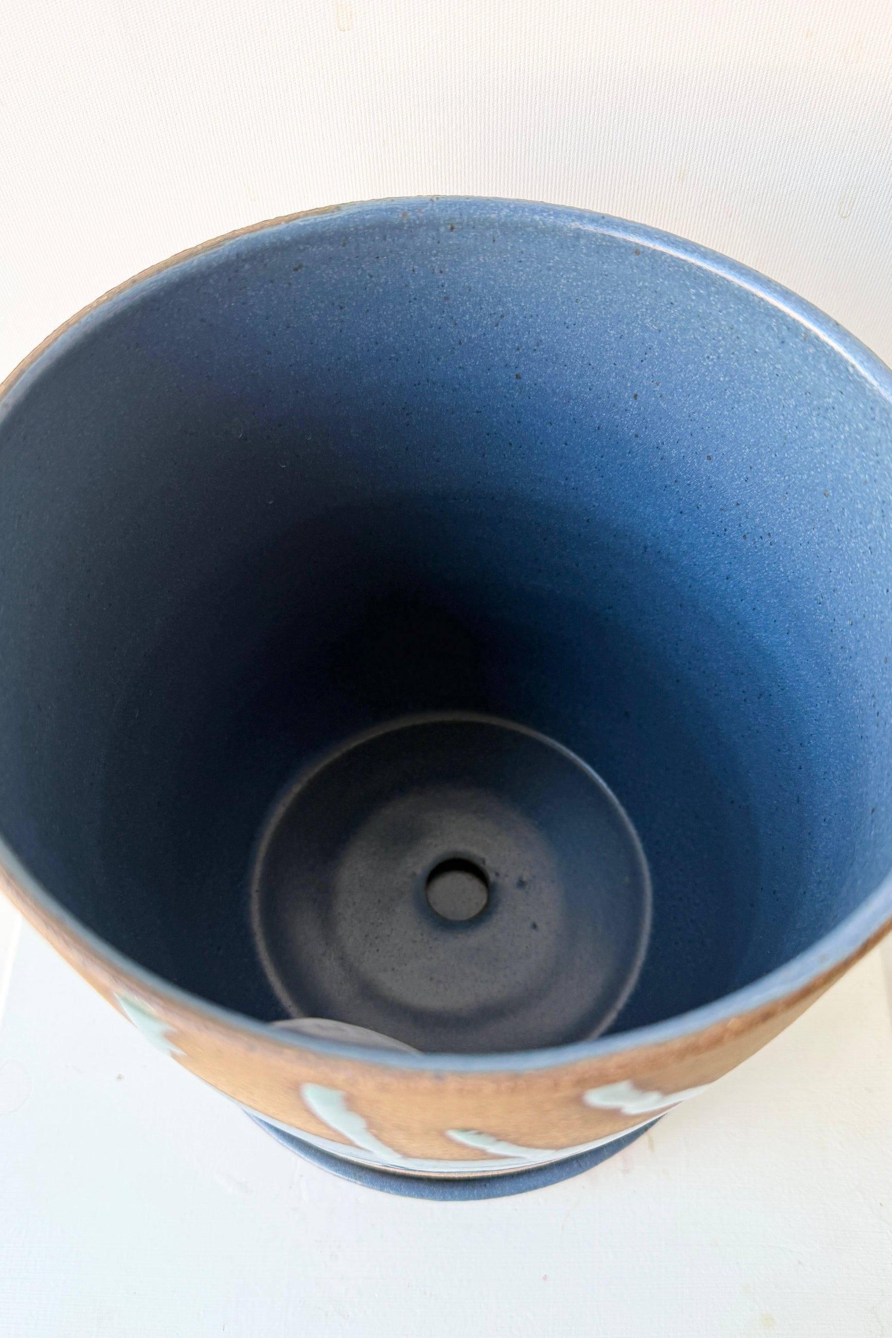 Close-up of the interior of a Cylinder Pot & Saucer Denim and Dark Teal Splash Glaze 6.5" on a white background ©Sprout Home