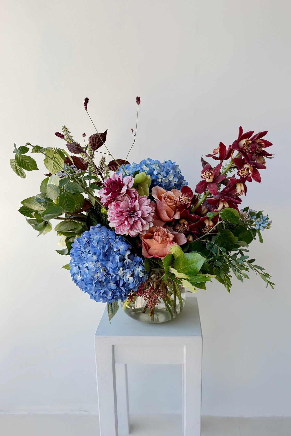 Unique flowers in shades of blue and brown w/ puffy and angular shapes create by Sprout Home Floral against a white wall ©Sprout Home #size_$200