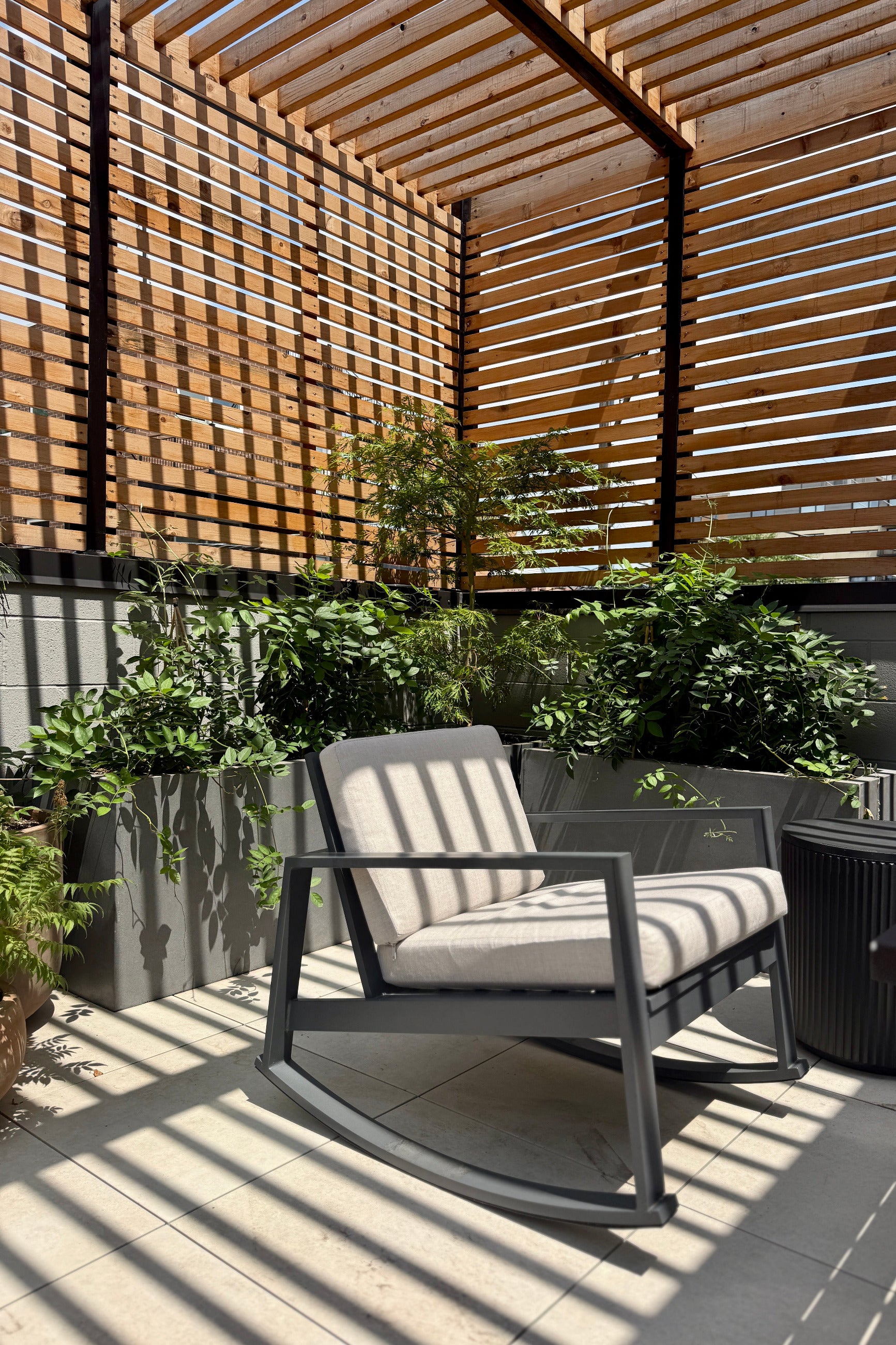 Planted Jumbo gray jort behind a chari, planted in a Sprout Home garden design ©Sprout Home