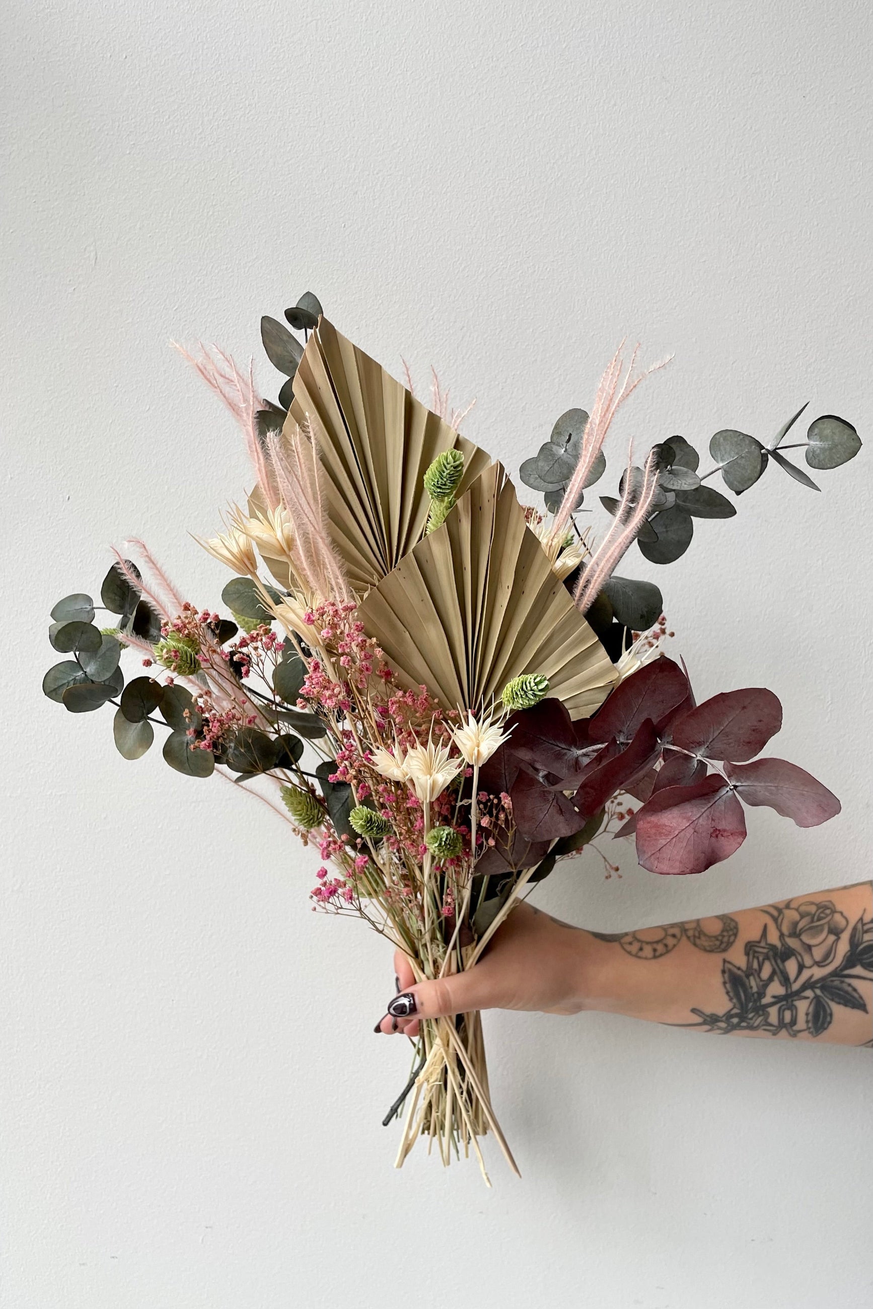 Sprout Home custom Faerie preserved arrangement being held in hand against a white wall. ©Sprout Home #size_$60