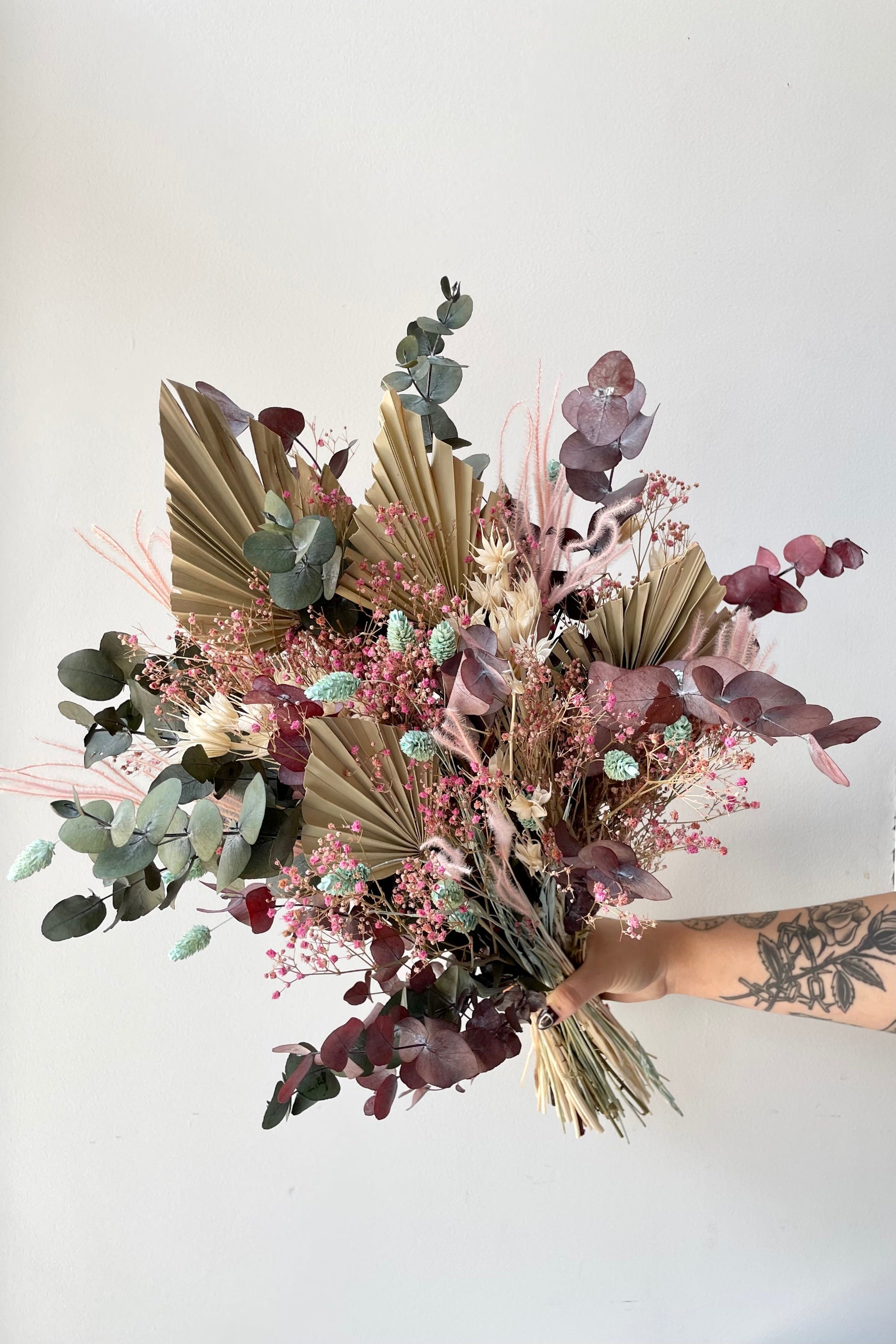 'Faerie' arrangement of shades of beige, pink and mint being held against white wall created by Sprout Home. ©Sprout Home #size_$125
