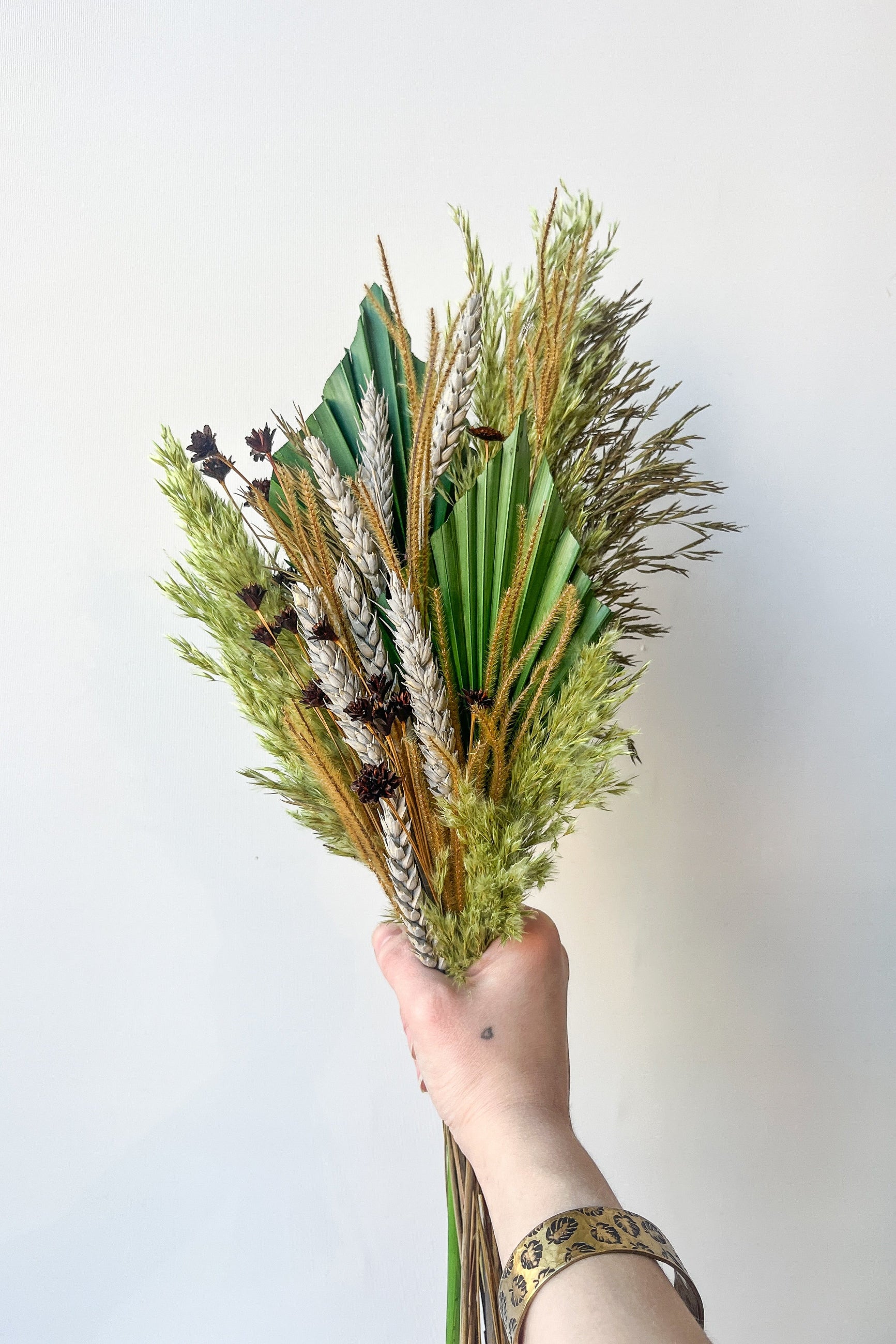 Custom preserved arrangement "Flora Borealis' created by Sprout Home and being held in hand ©Sprout Home. #size_$60