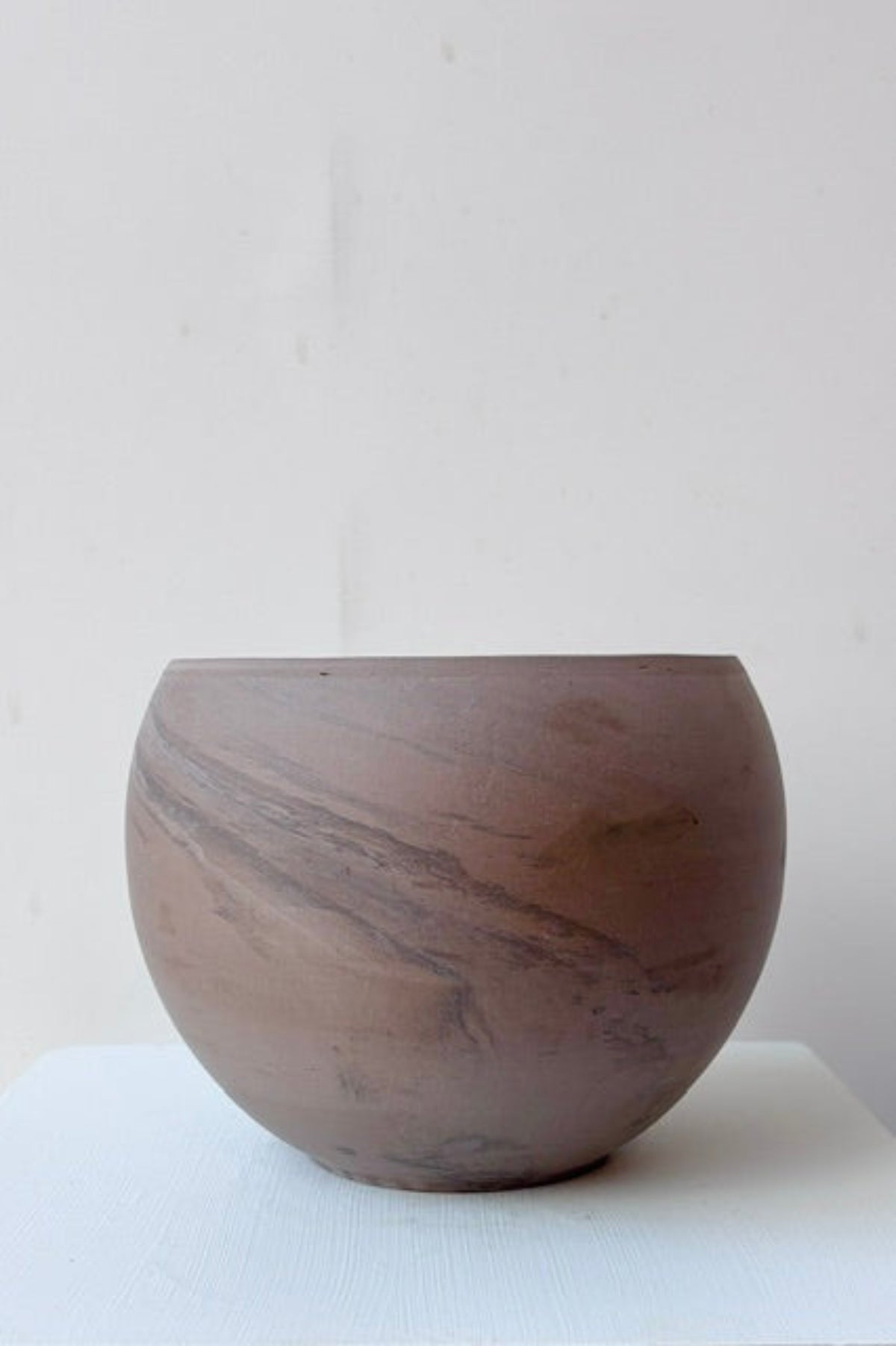 Sphere shaped grey/brown planter against a white background ©Sprout Home